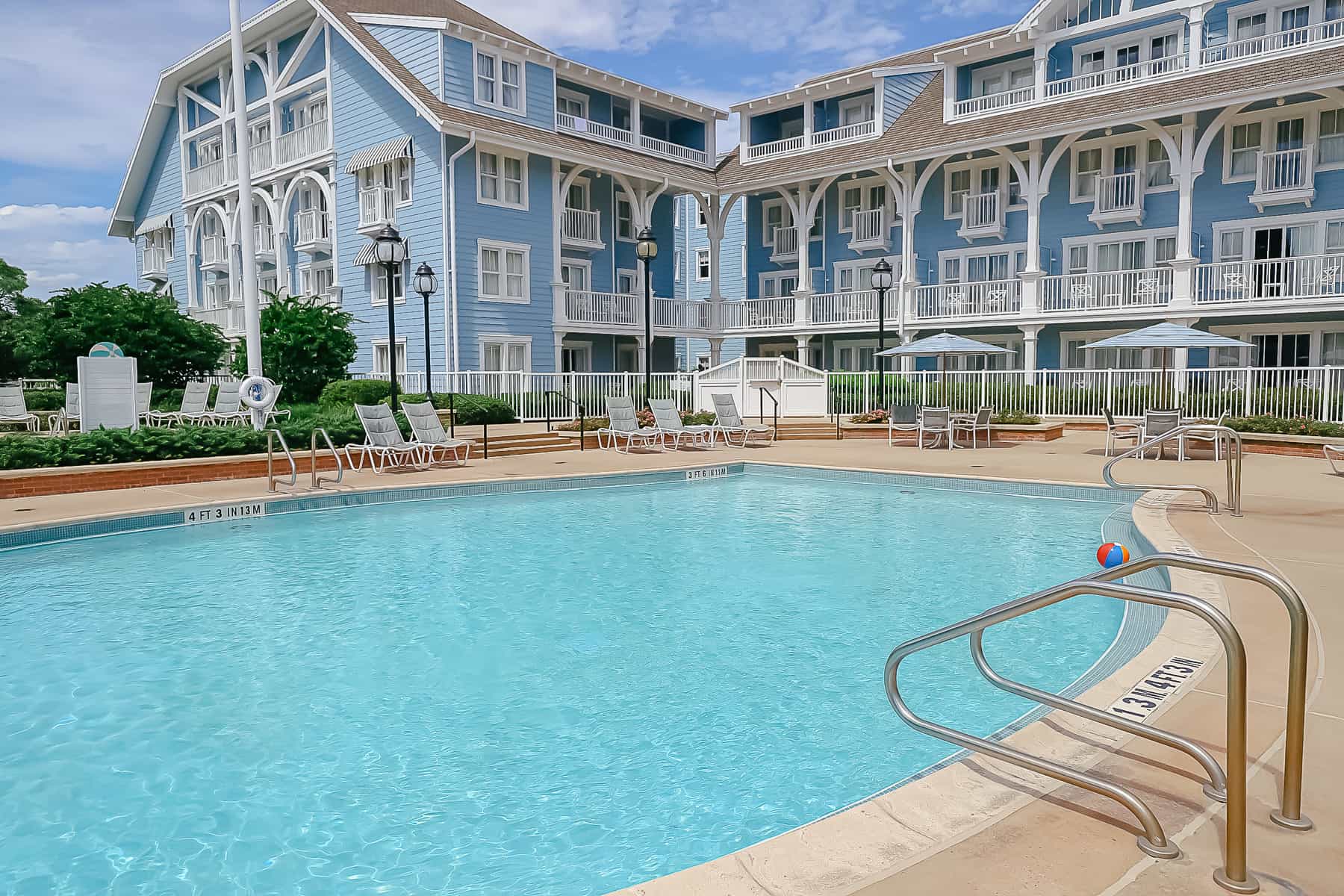 a smaller quiet pool with blue water and a Disney Resort in the backdrop 