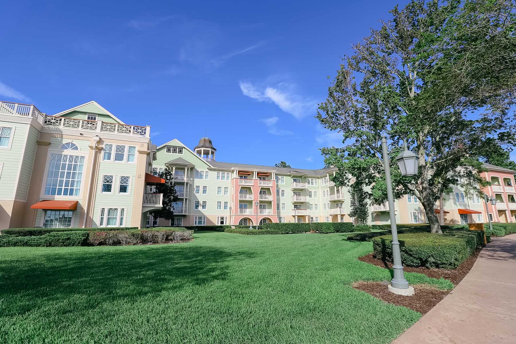 Disney's Saratoga Springs Resort exterior with light greens and pinks. 