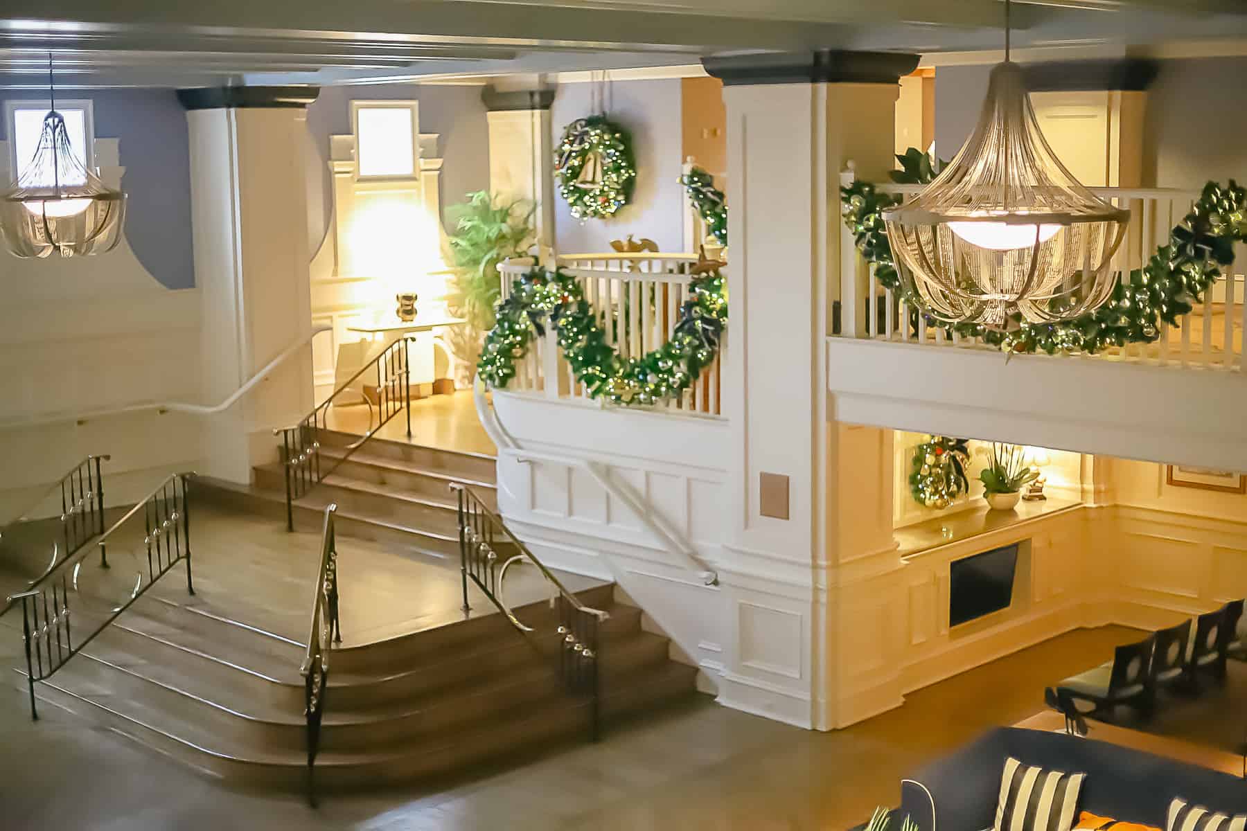 view of the staircase off the lobby trimmed in garland