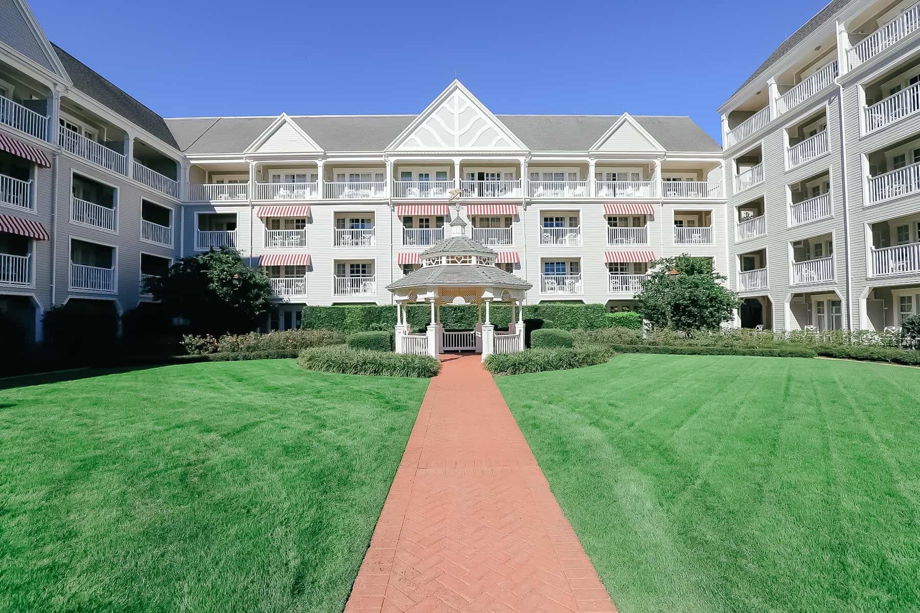 disney yacht gazebo with crisp green grass and red paver walkway