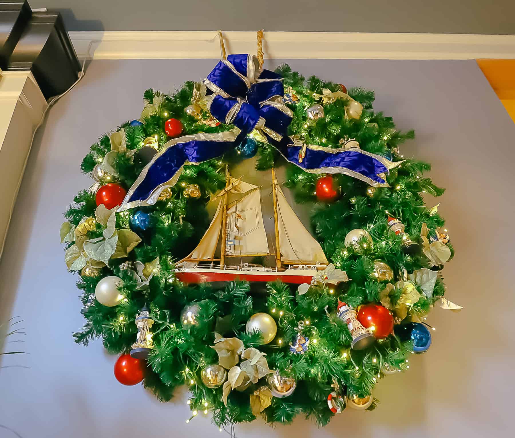 a Christmas wreath with a sailboat and lighthouses 