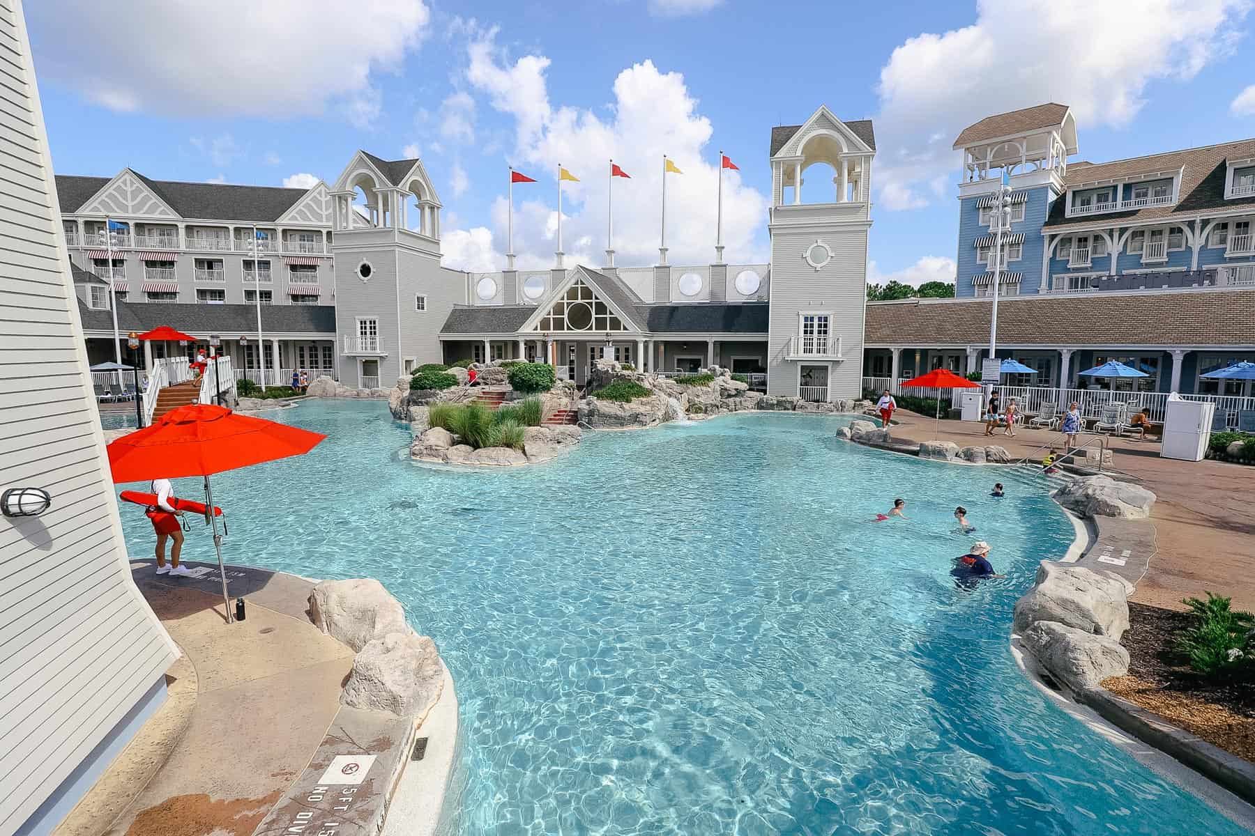 the Stormalong Bay Pool area at Disney's Yacht Club: a pool with red and yellow flags in the background 