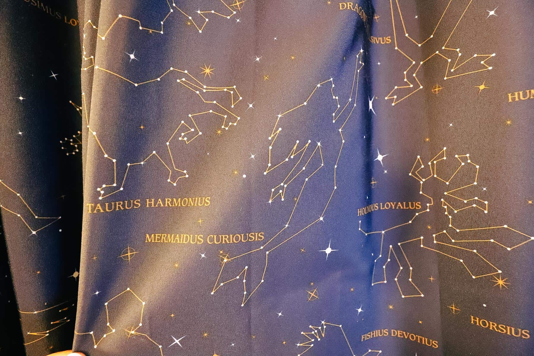 curtains that are dark navy blue with golden constellations and Disney characters