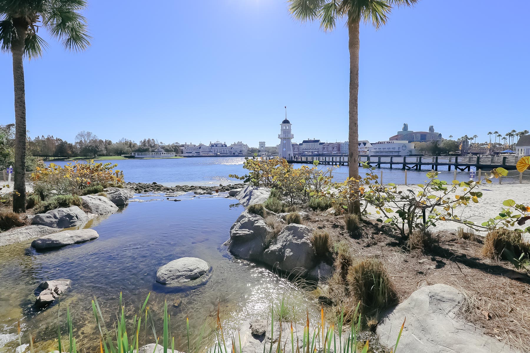 a stream that leads to the lake at Disney's Yacht Club with the lighthouse in the distance 