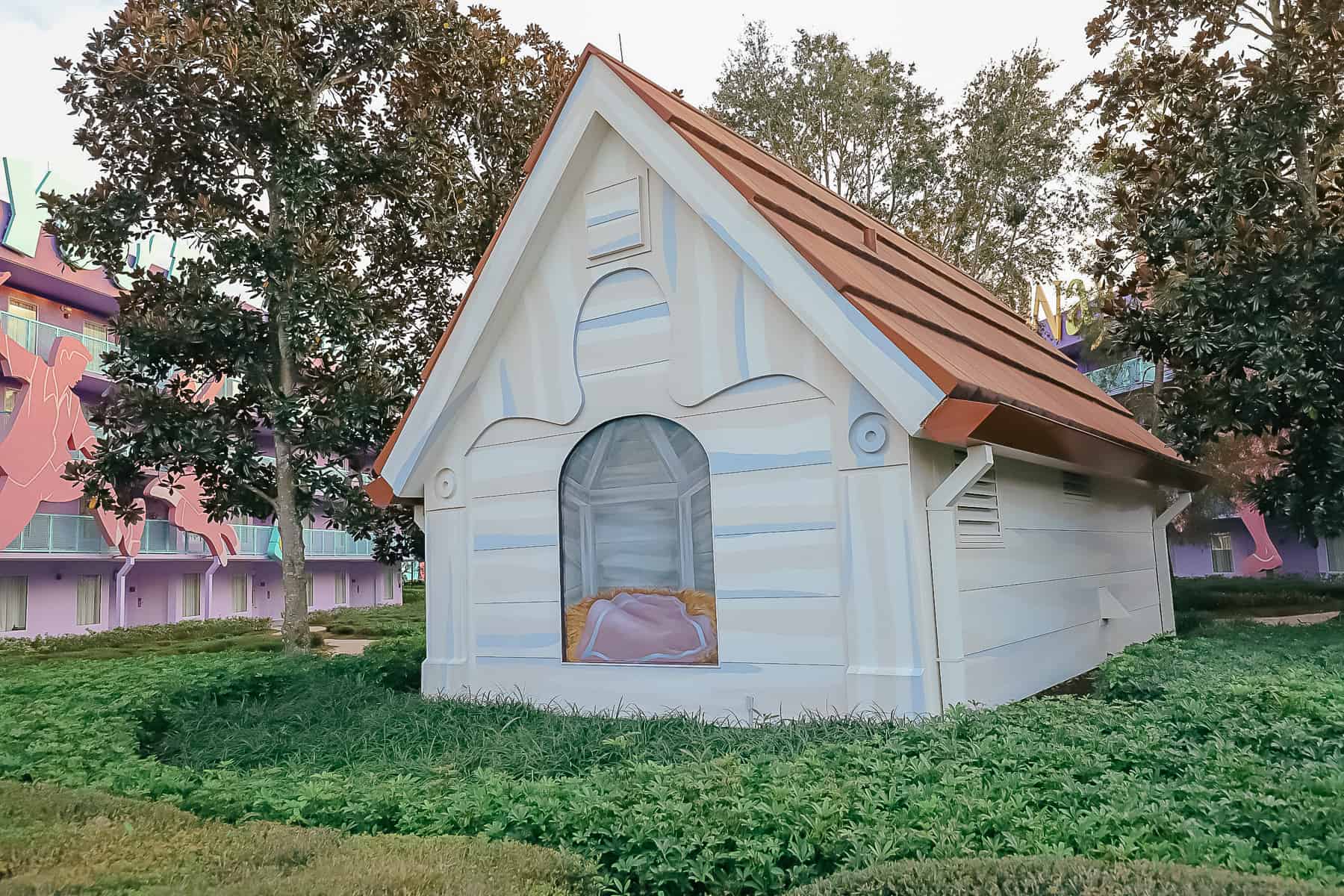 a larger than life dog house sits in the middle courtyard of Pop Century 