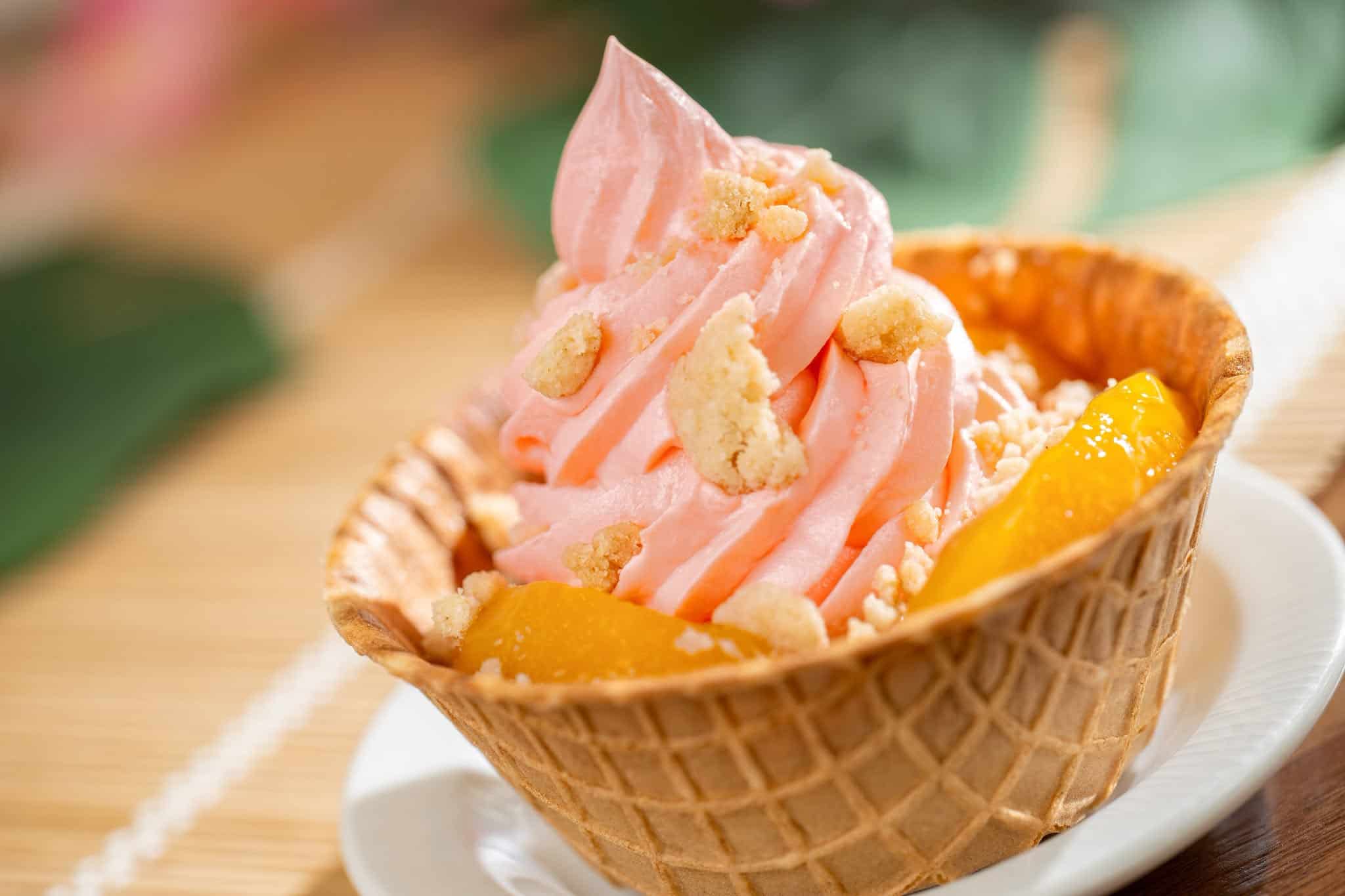 a sundae in a waffle cone bowl with peach Dole Ship