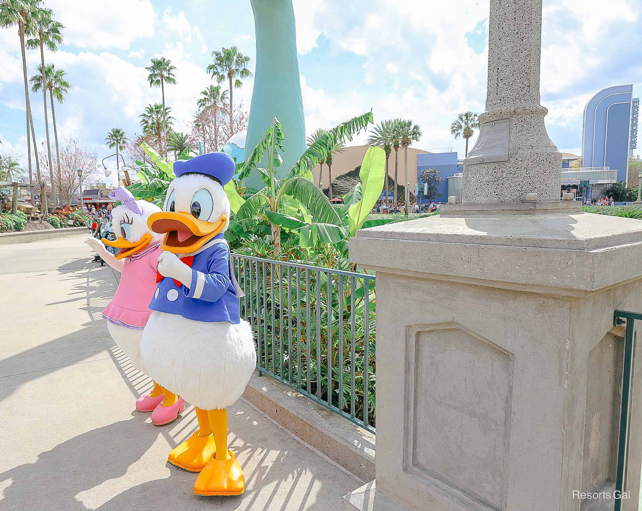 Donald and Daisy Duck talking and waving to guests. 