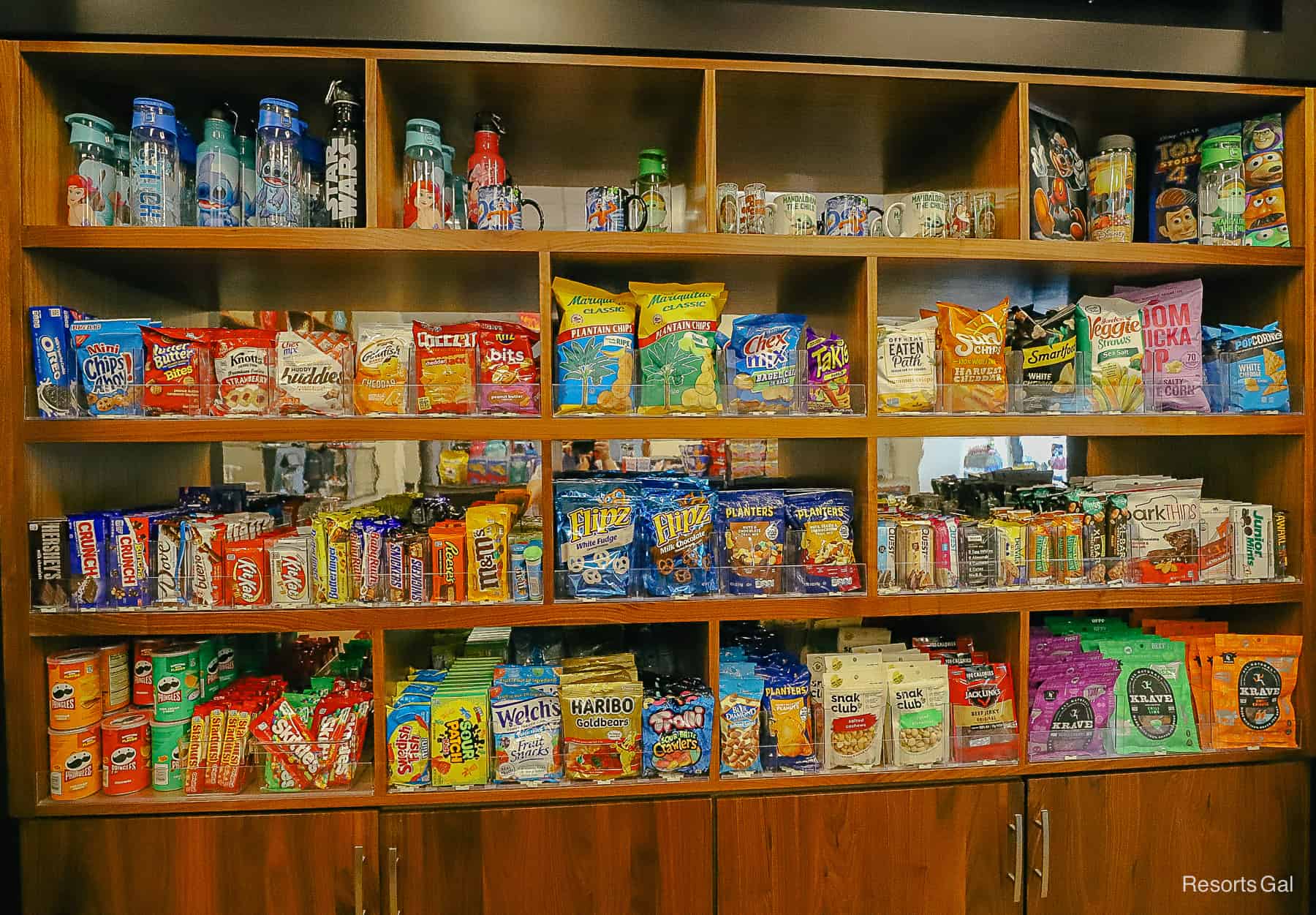 A display with a variety of snacks, chips, candy, and similar items. 