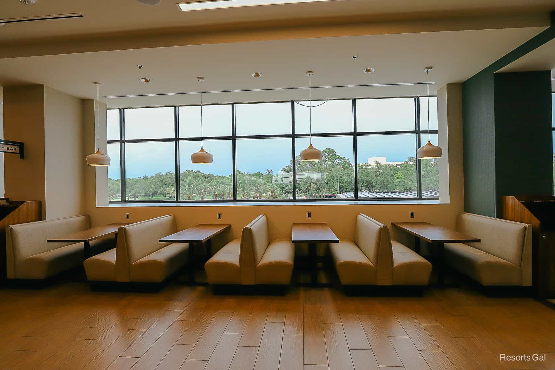 a row of booths next to a wall of windows 