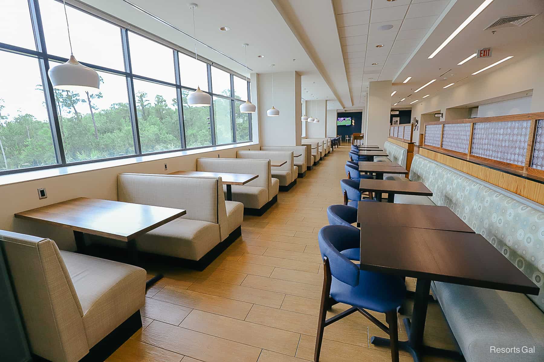 a row of booths on the left side and tables with banquettes on the right side 