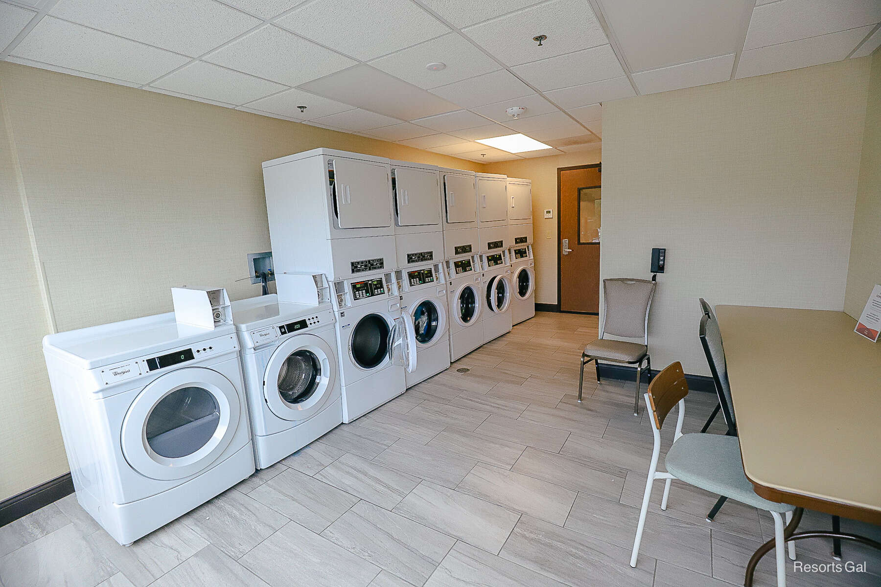 laundry room wish washers, dryers, and a table with chairs 