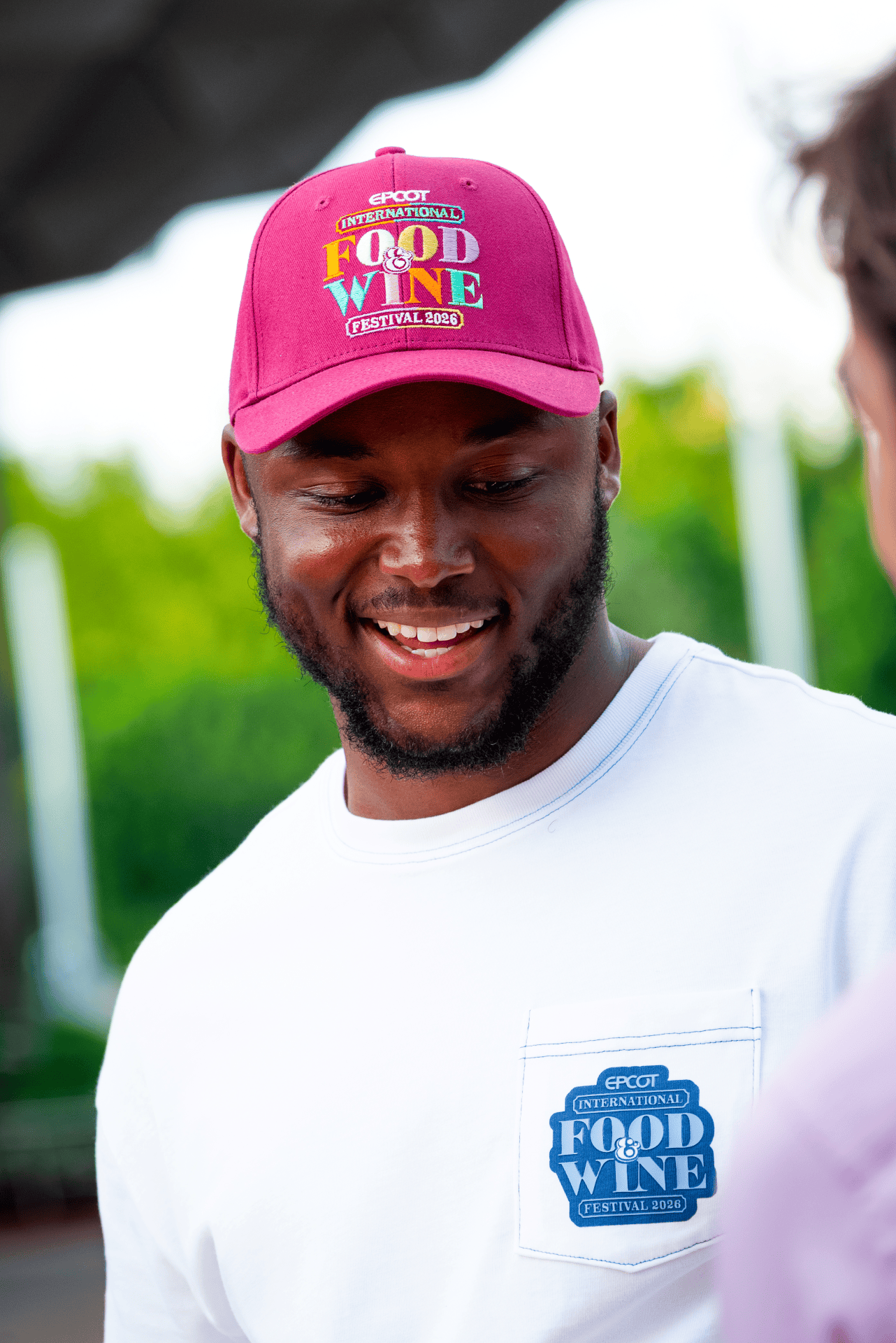 a person wearing a Food and Wine baseball cap