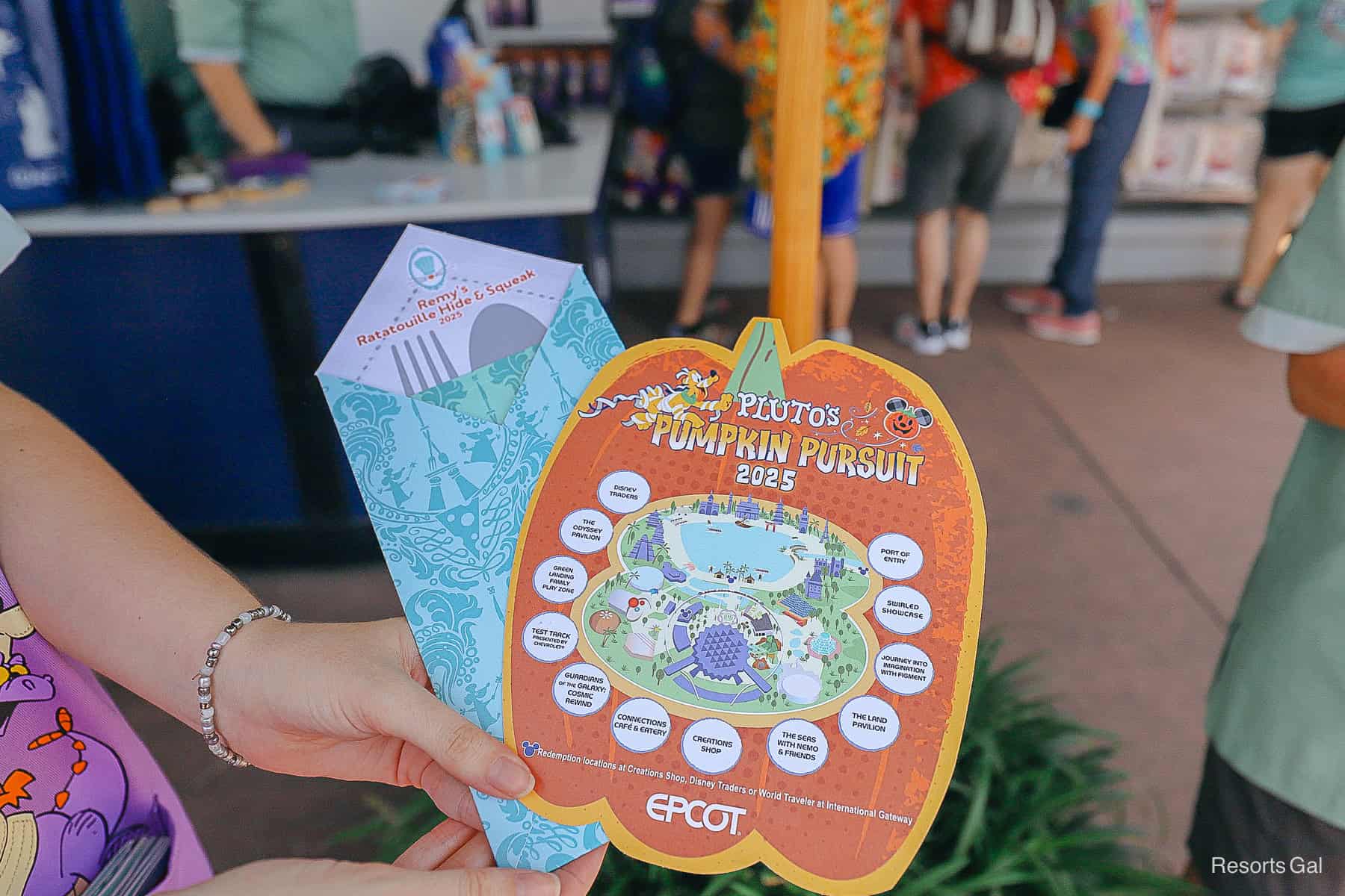 a cast member holds out two maps for photos