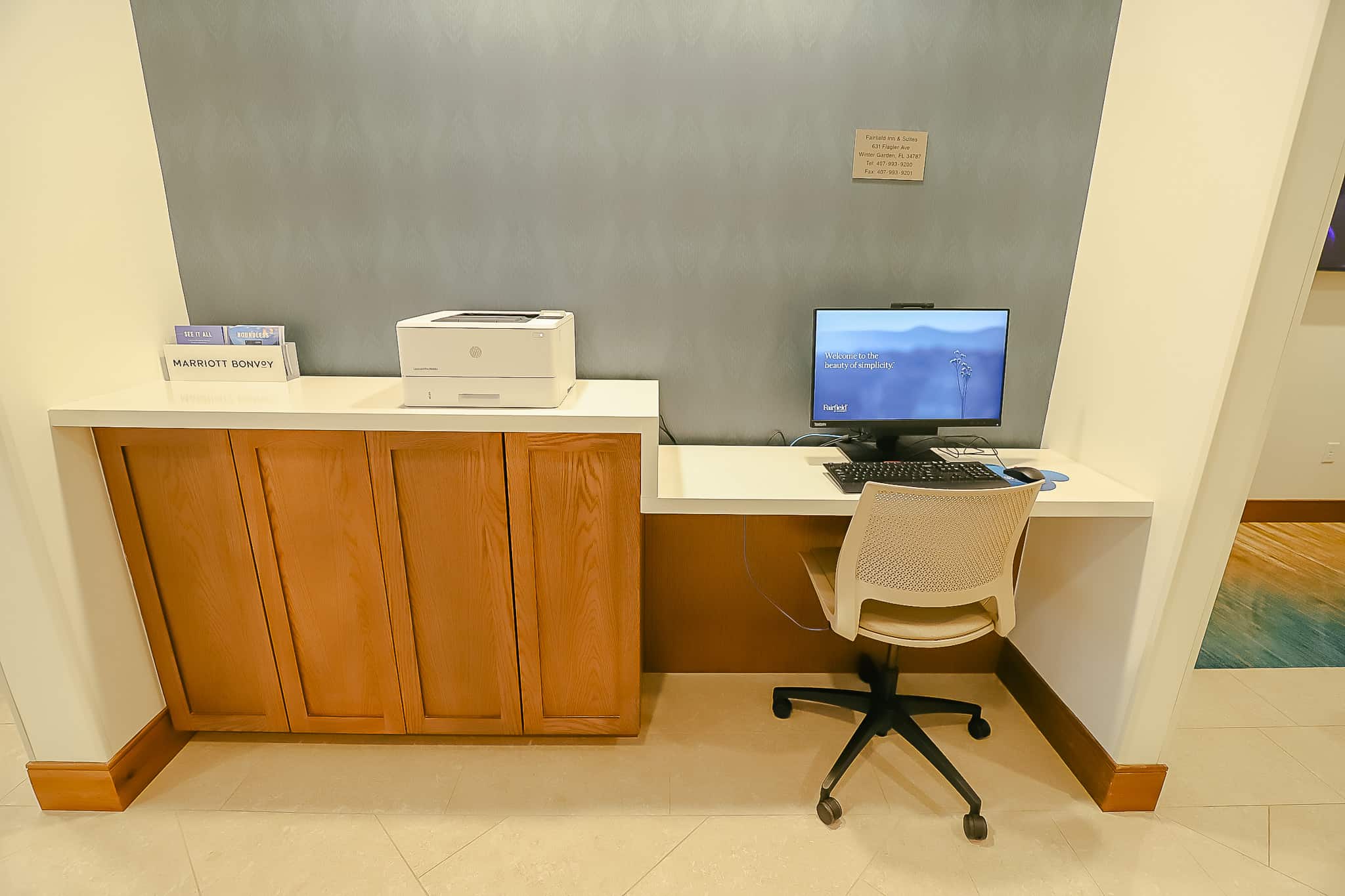 a workstation at the hotel with a computer and chair 