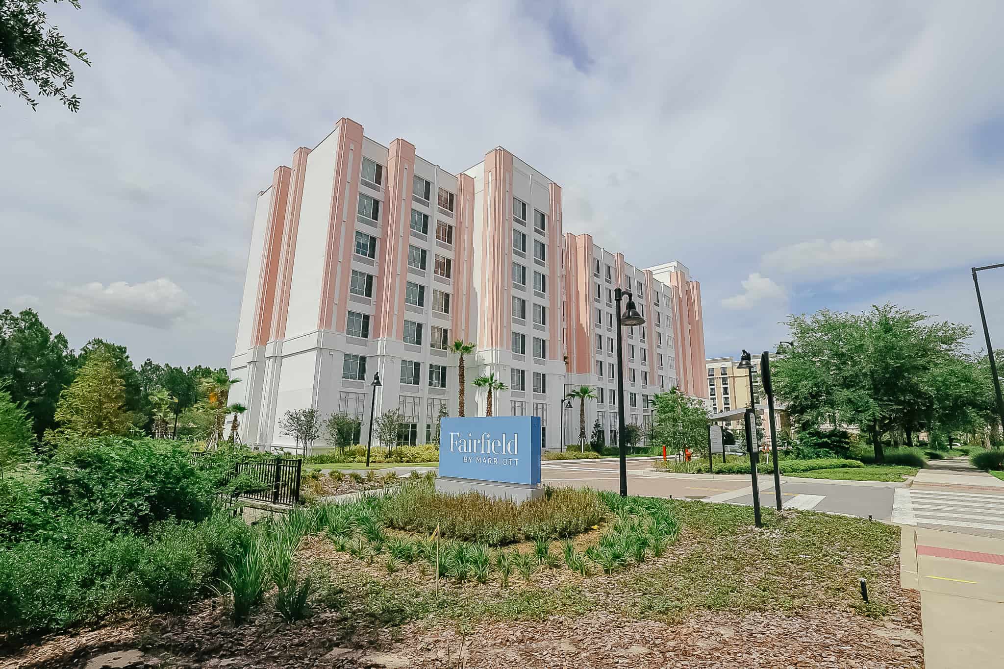 The Fairfield by Marriott is a pink hotel with white trim. 