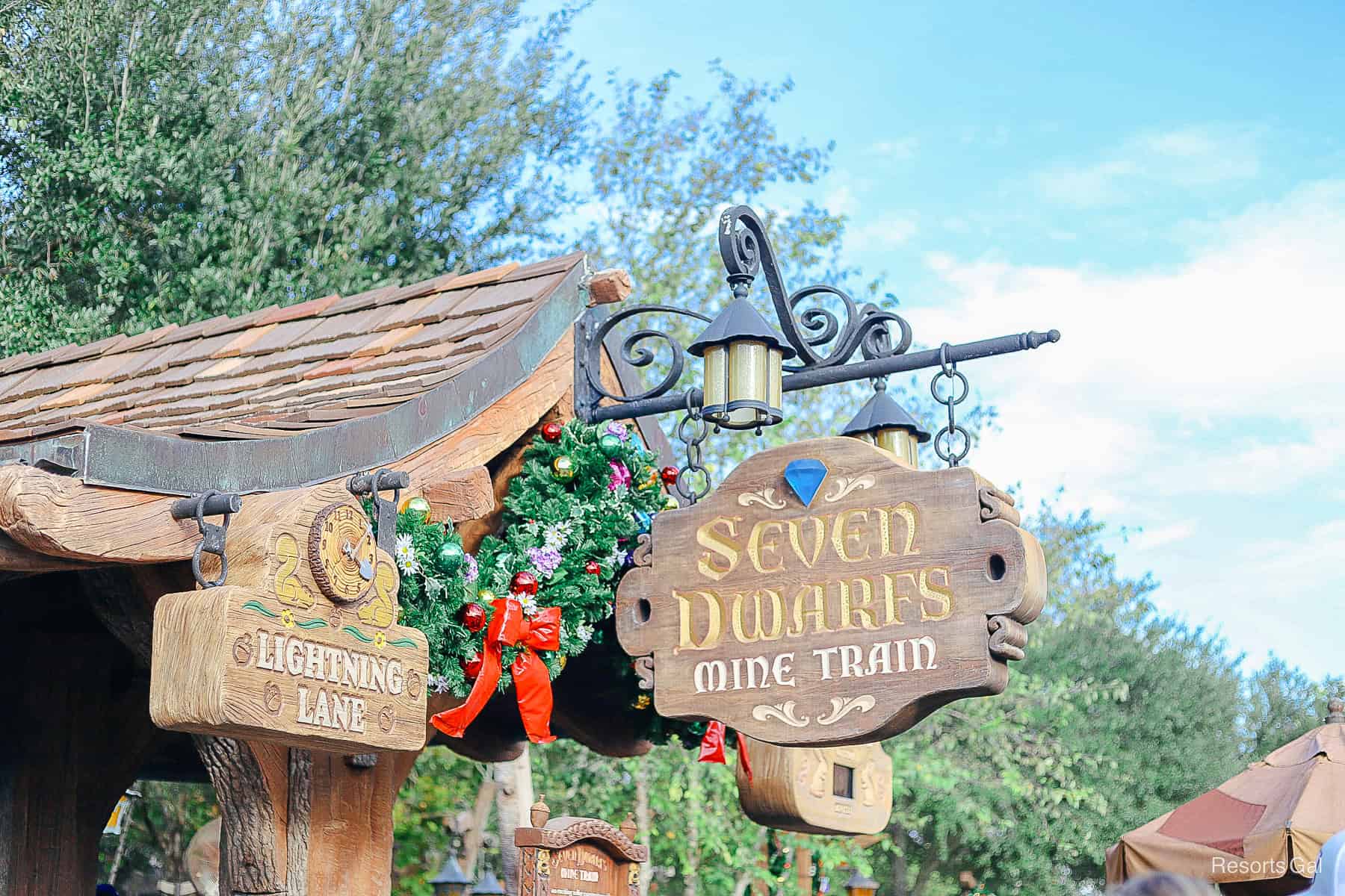 the sign for Seven Dwarfs Mine Train wrapped with garland 