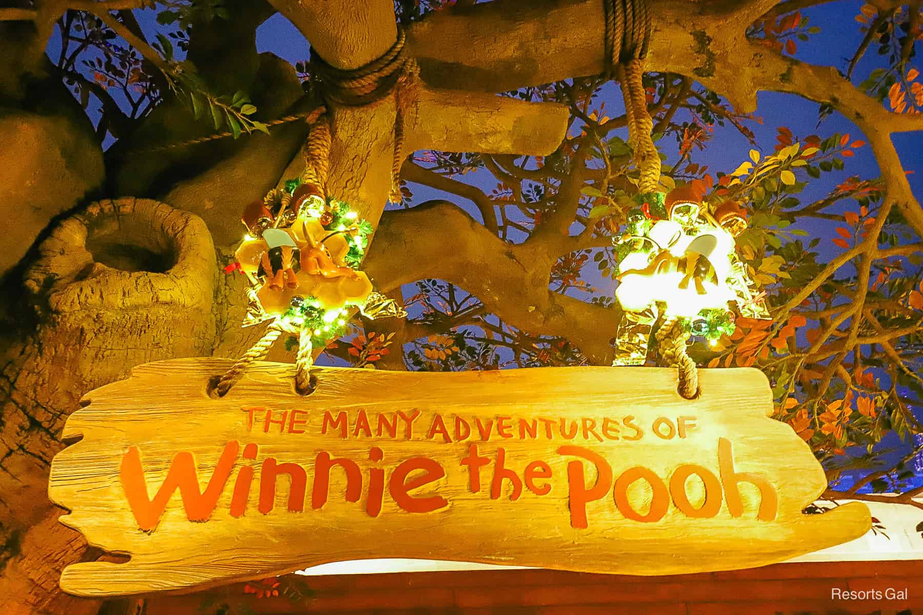 the sign for the Many Adventures of Winnie the Pooh in Fantasyland decorated for Christmas 