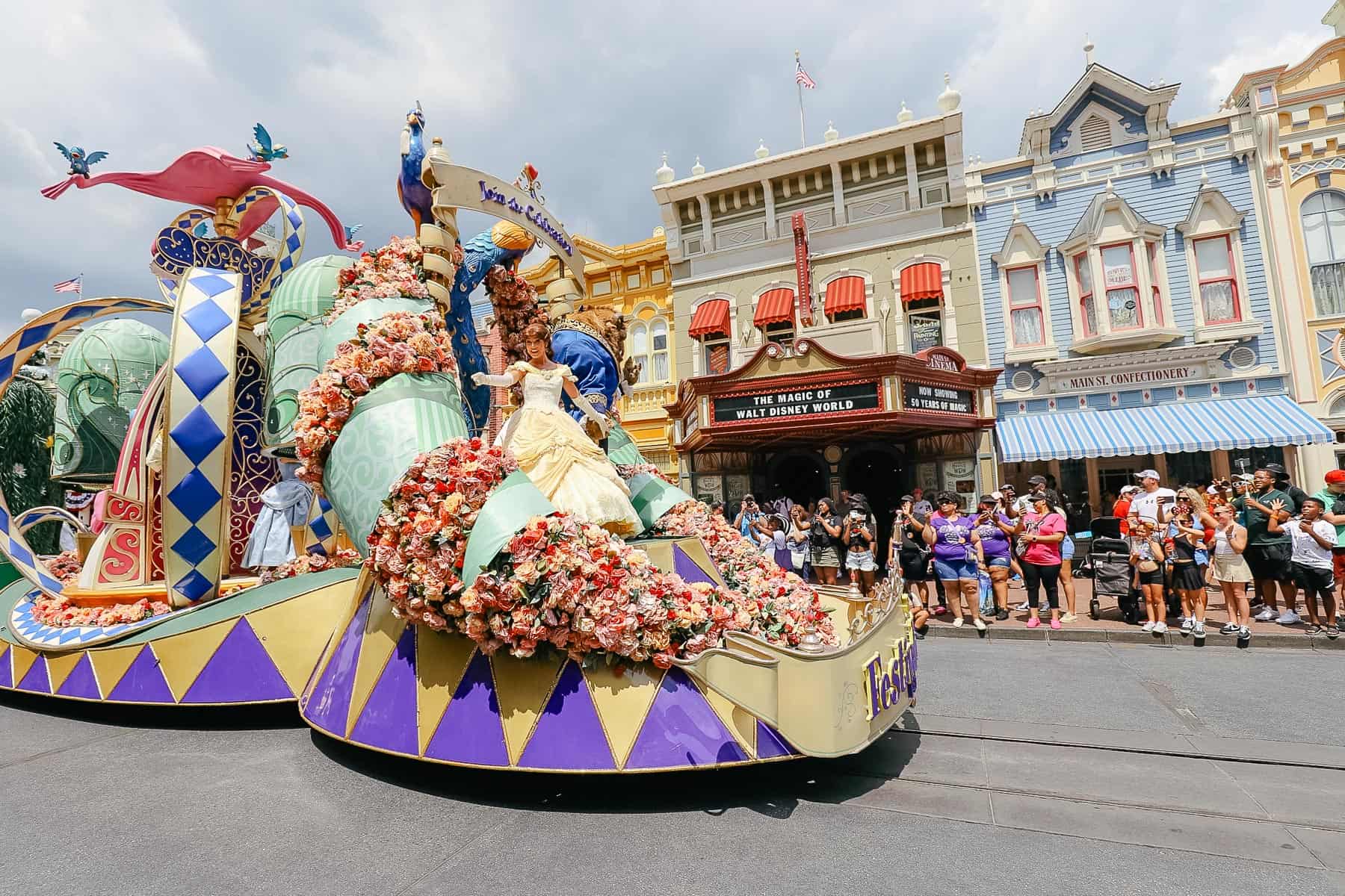 Belle waves to guests from a float in the parade. 