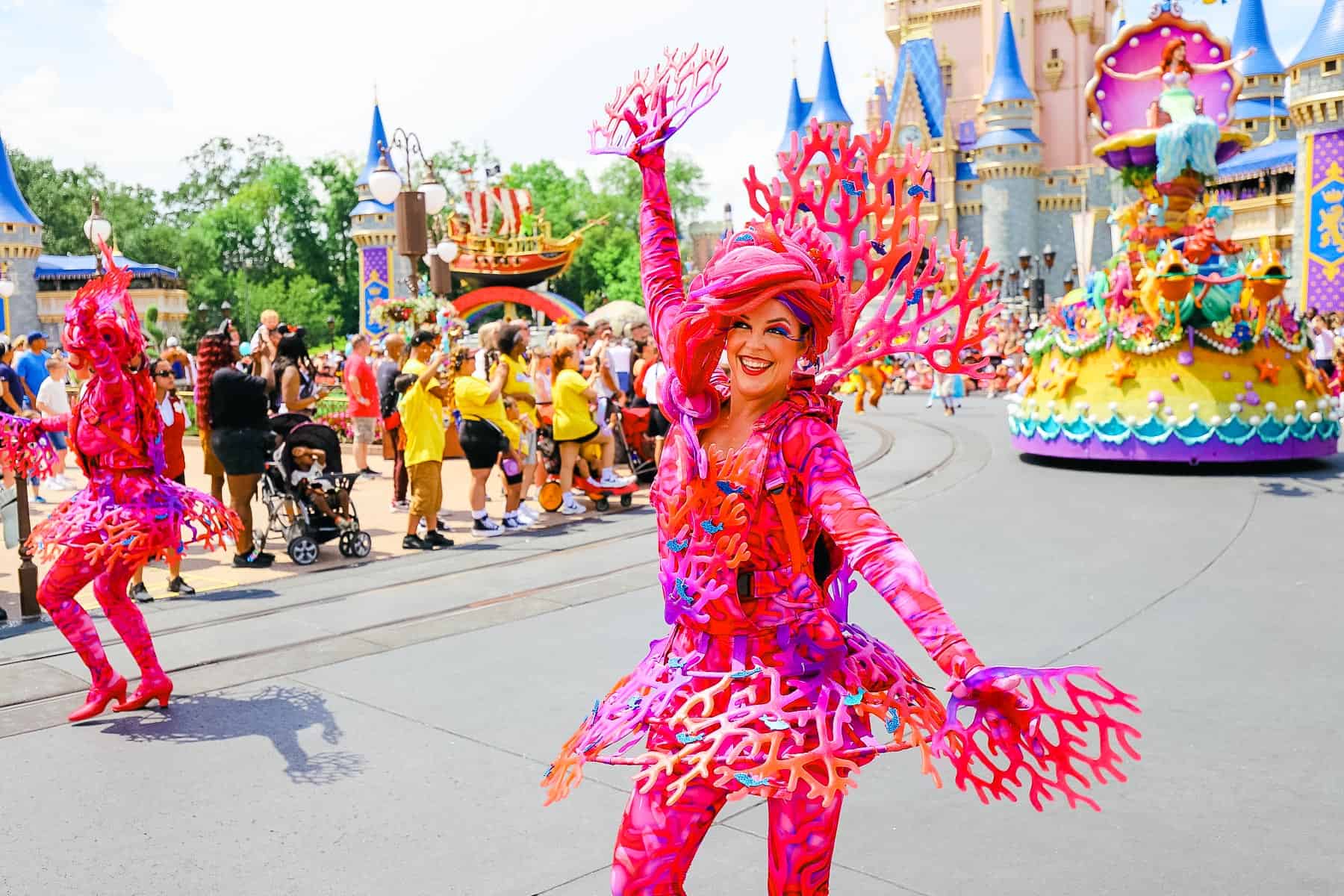 Dancers with coral accents in the parade at Magic Kingdom. 