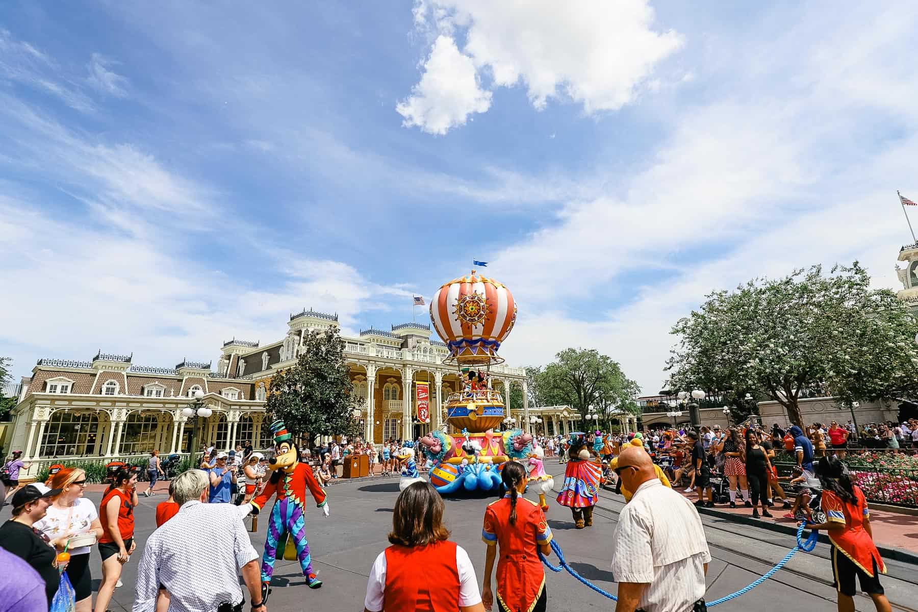 Cast members carry a rope at the end of the parade as it passes through Town Square. 