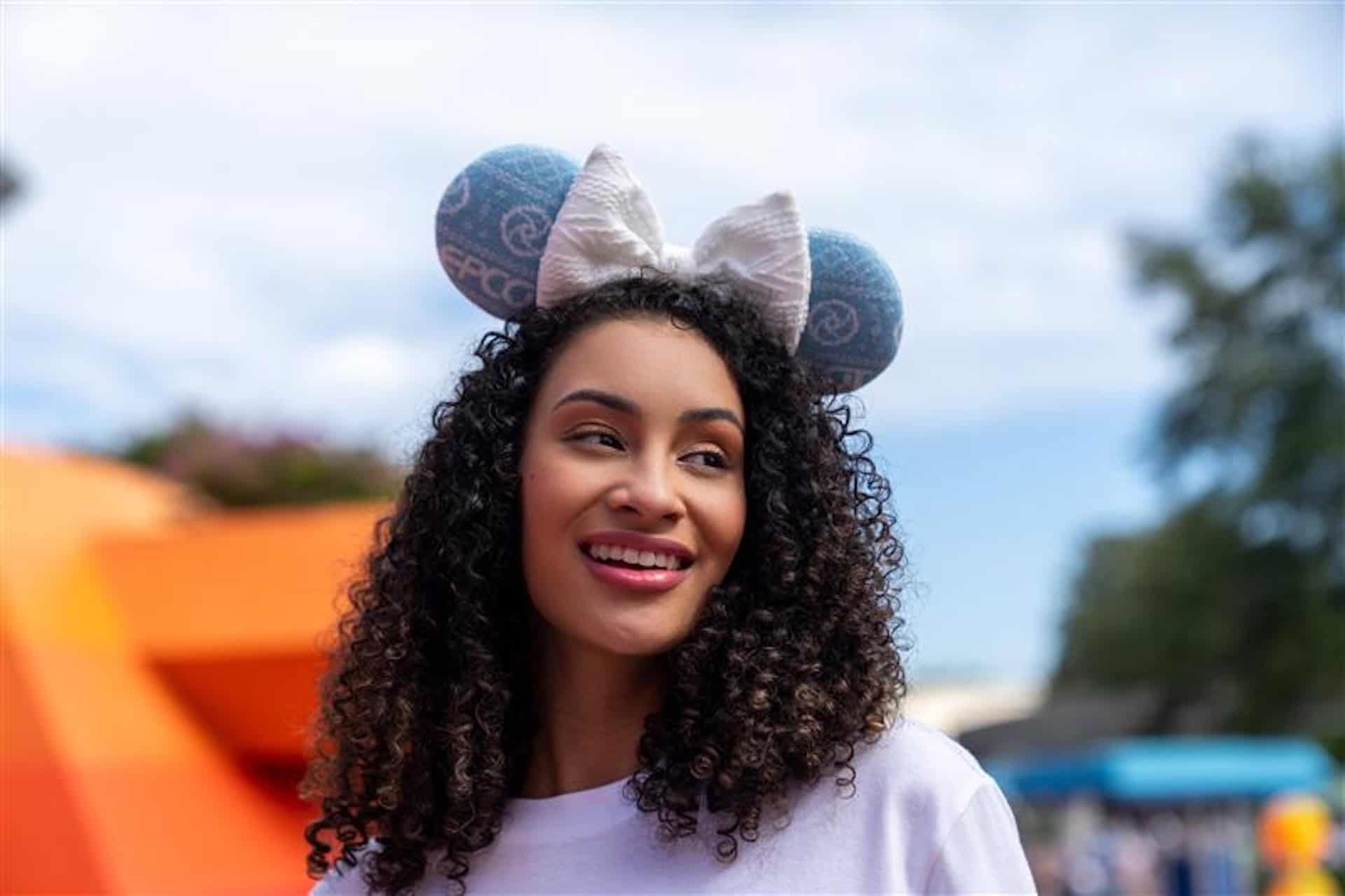 a girl wearing Figment Ugly sweater ears with a white bow 