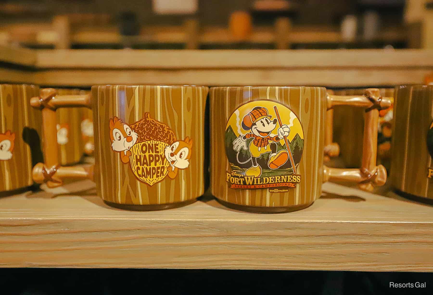 A mug that says One Happy Camper on one side and Mickey Mouse. with the Fort Wilderness logo