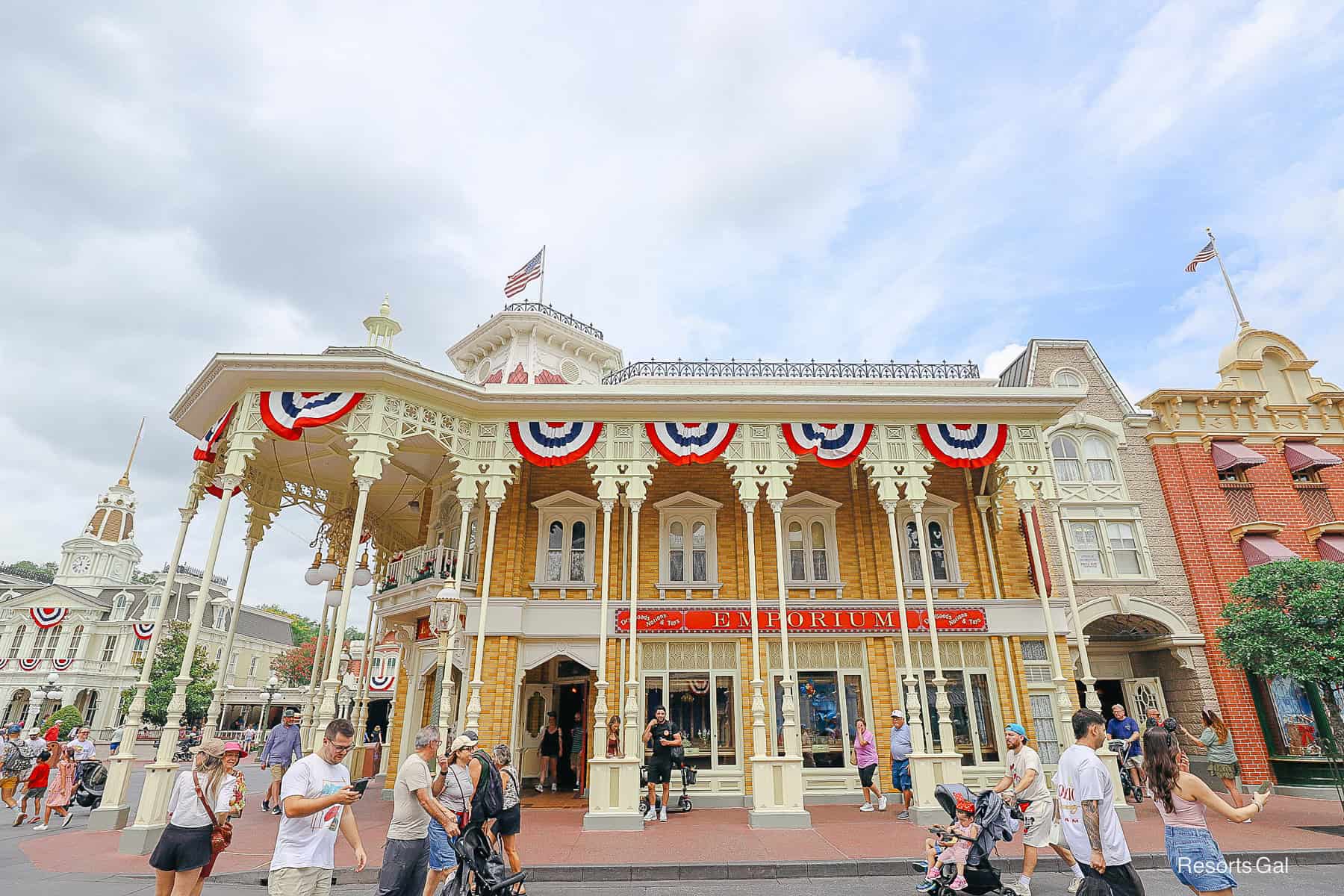 guests walking by the red, white, and blue decorations on the Emporium at Magic Kingdom 