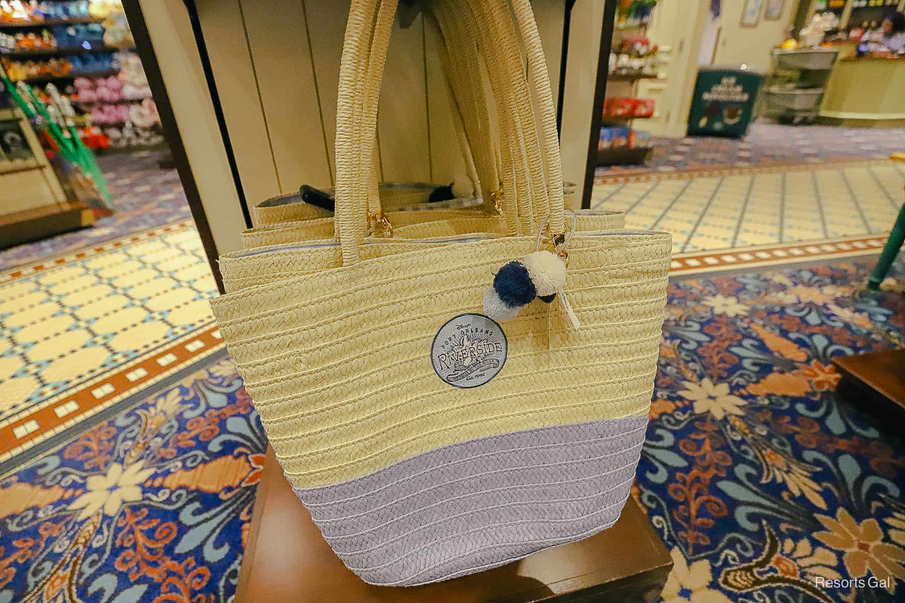 a blue and straw bag with the Port Orleans Riverside logo 