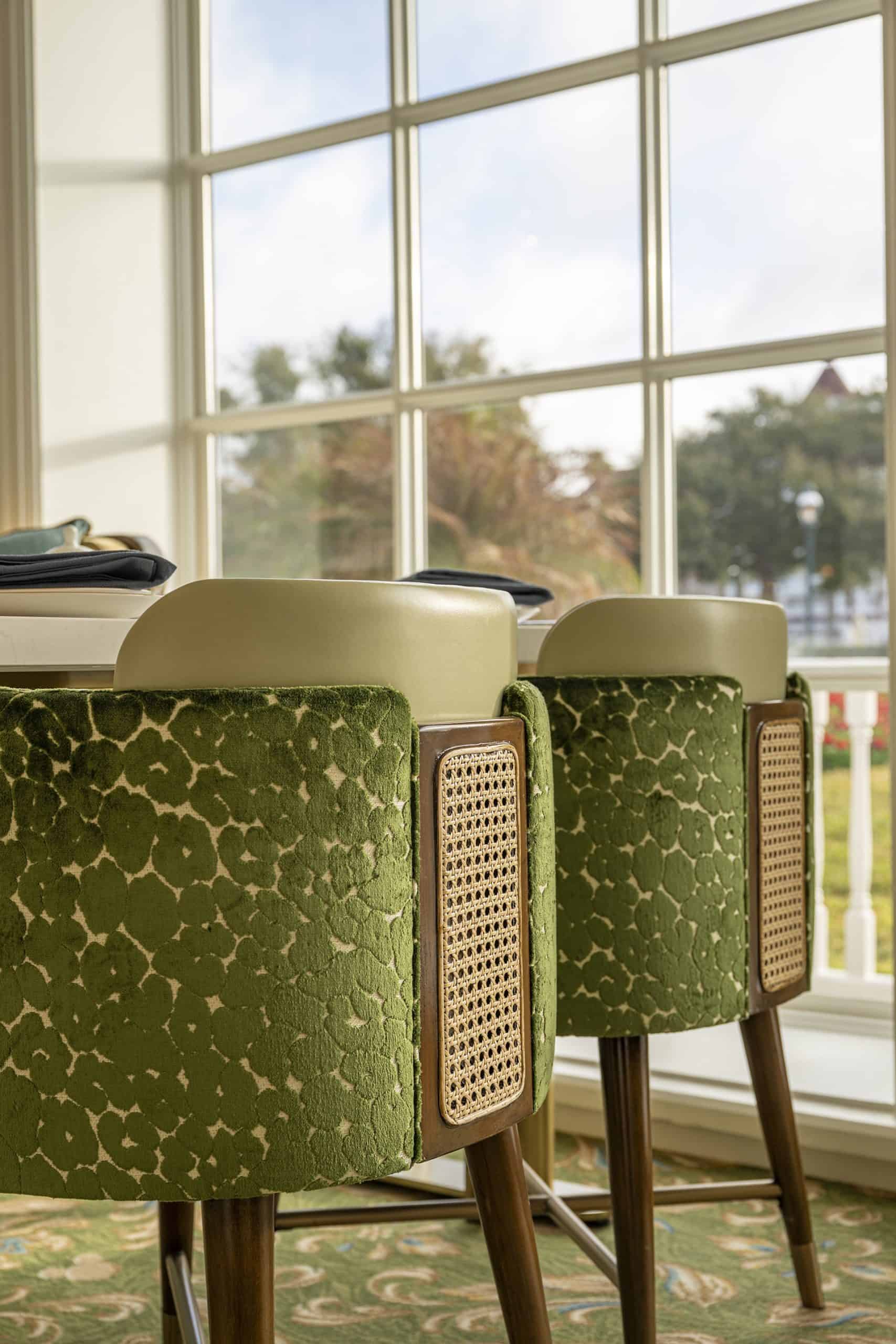 a closeup of the back of a chair with rattan and green fabric