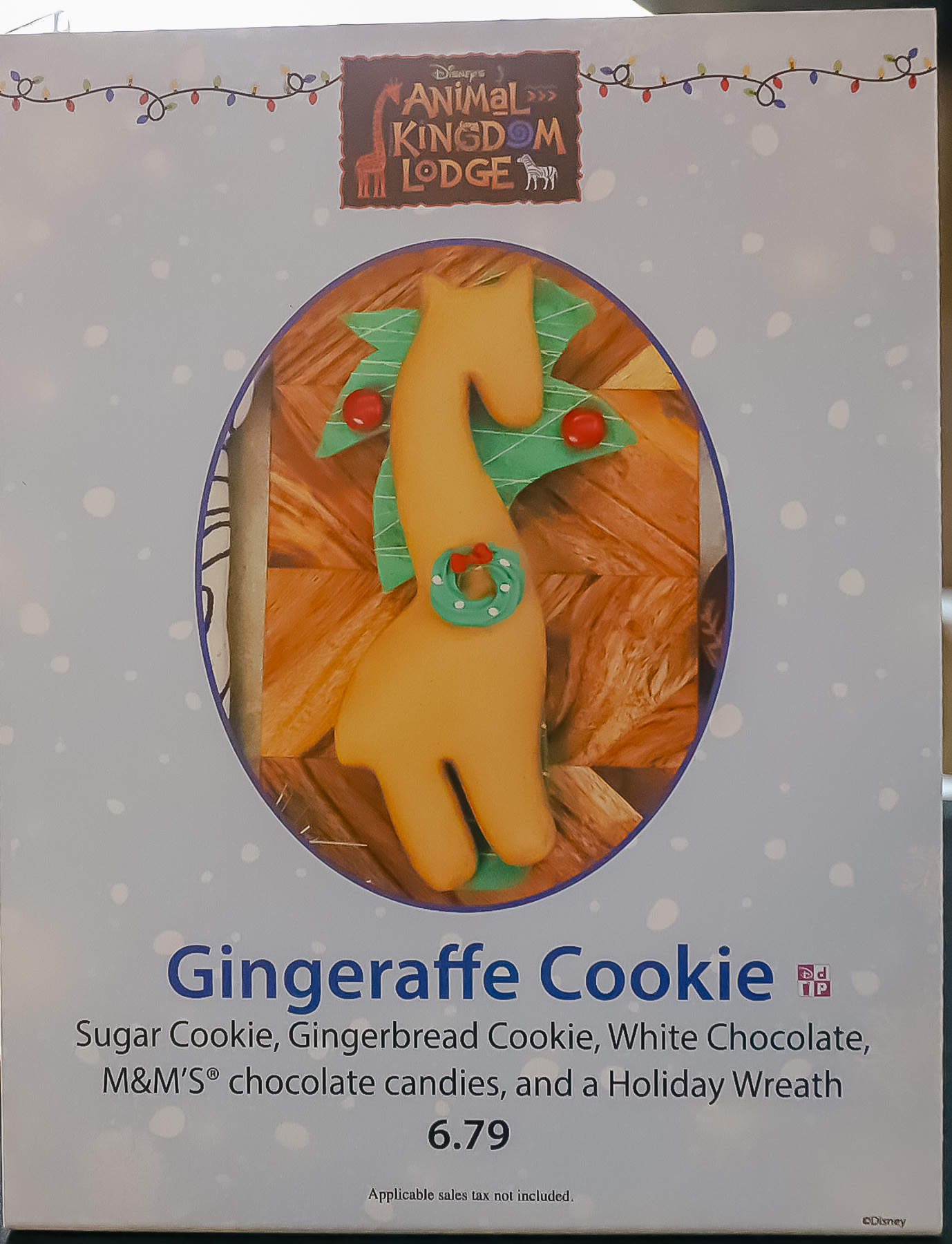 gingerbread animal kingdom lodge gingeraffe cookie gingeraffe cookie sign that says "M&M's, gingerbread cookie, white chocolate, and a holiday wreath fro $6.79"