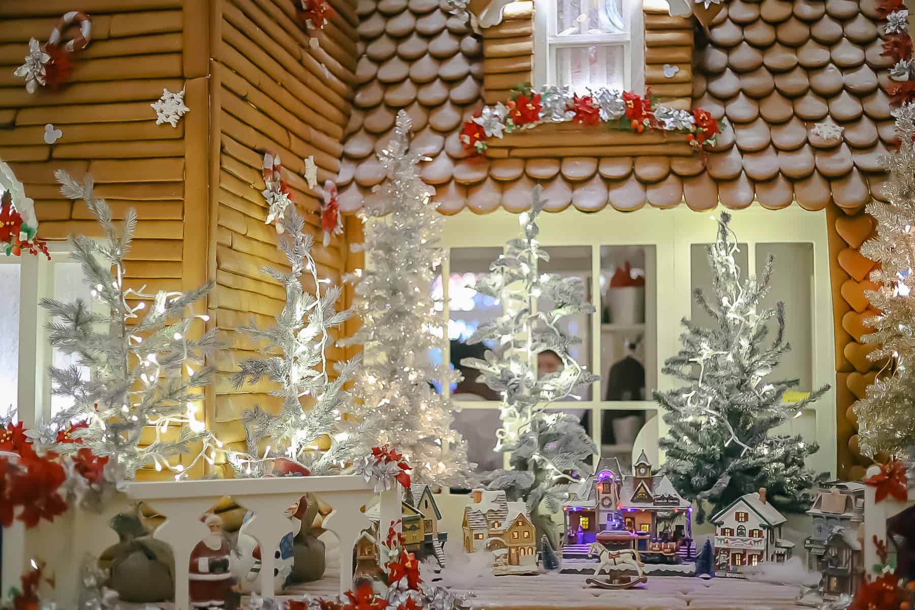 A Christmas village set up on one of the porches of the gingerbread house. 