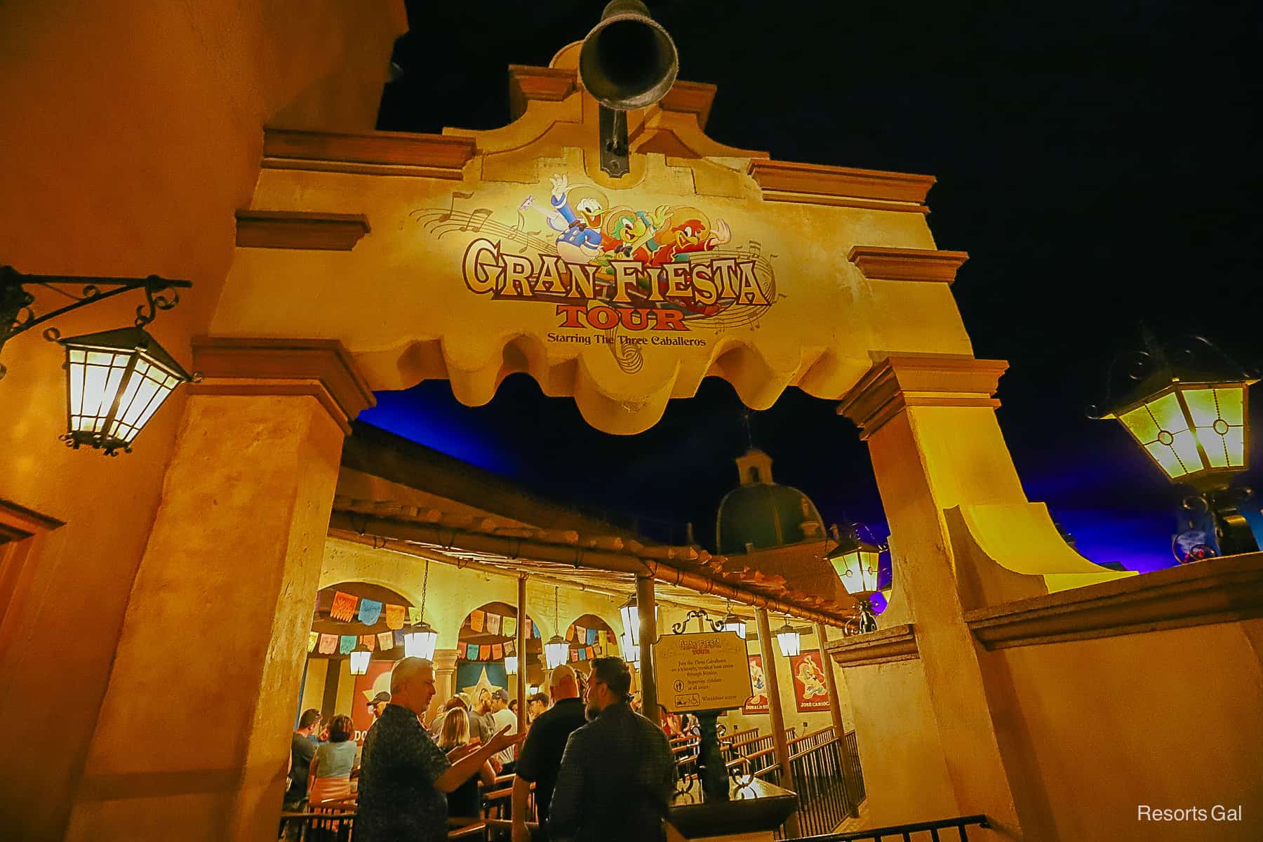 entrance to the queue for Gran Fiesta Tour with The Three Caballeros waving overhead. 