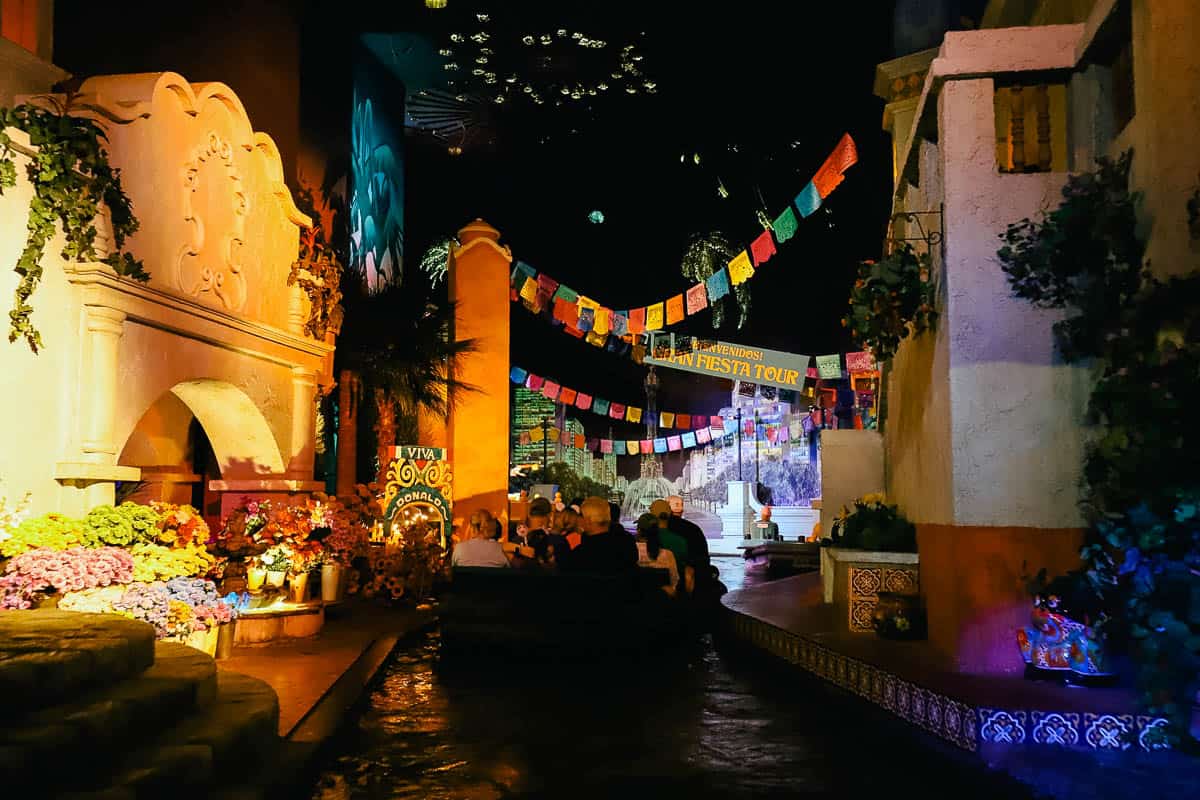 A boat of guests floating through the Gran Fiesta Tour attraction. 