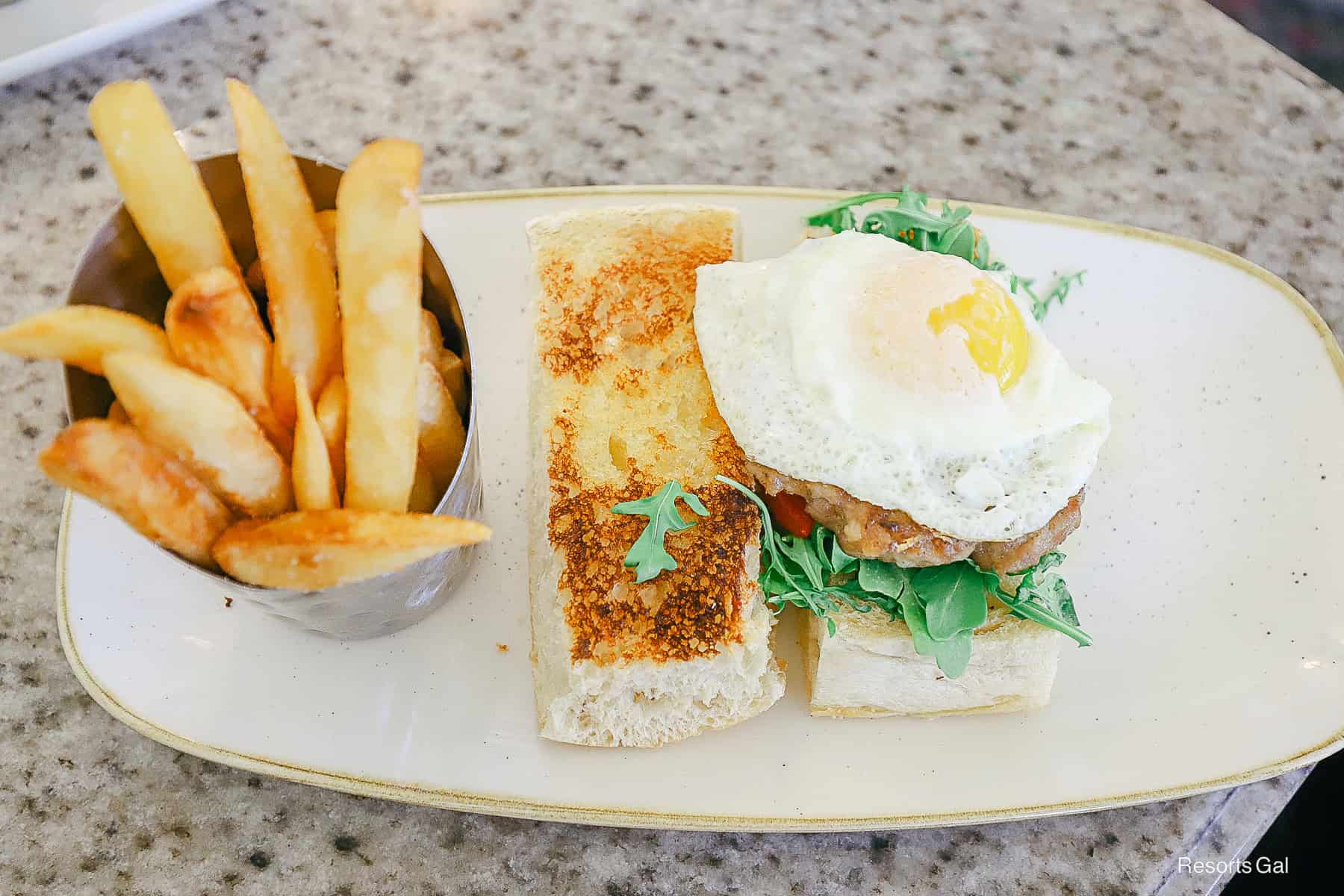 an order of steak fries on the plate next to the breakfast sandwich