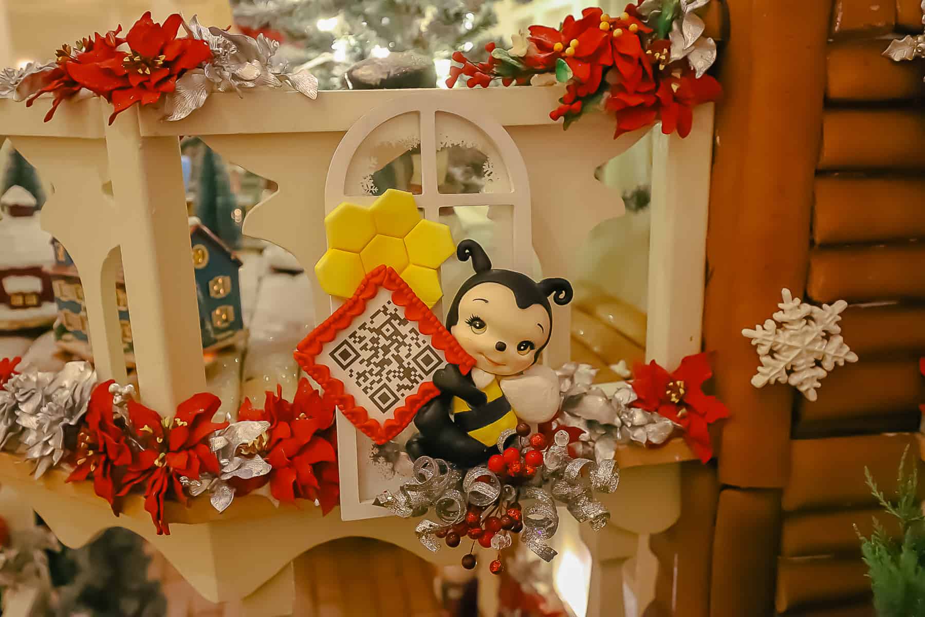 A bee figurine holding a QR code. The code links to information about how the house will be used as a food supply for bees once its deconstructed. 