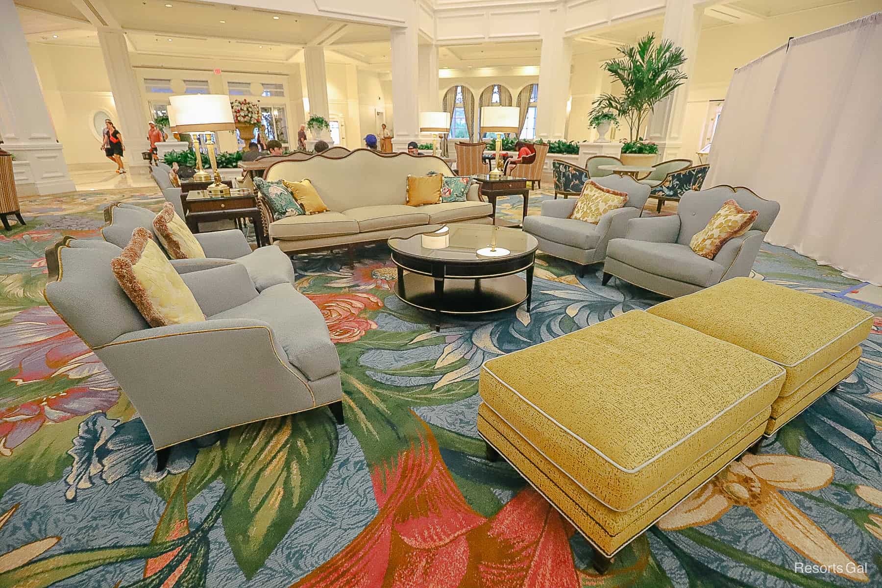 a new seating arrangement with a sofa, chairs, and ottomans 