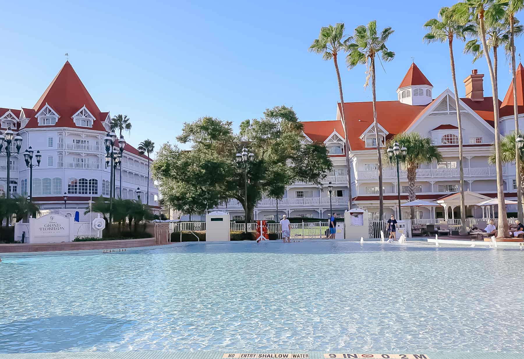 an overview of the Courtyard Pool with the Grand Floridian's red roof in the background 