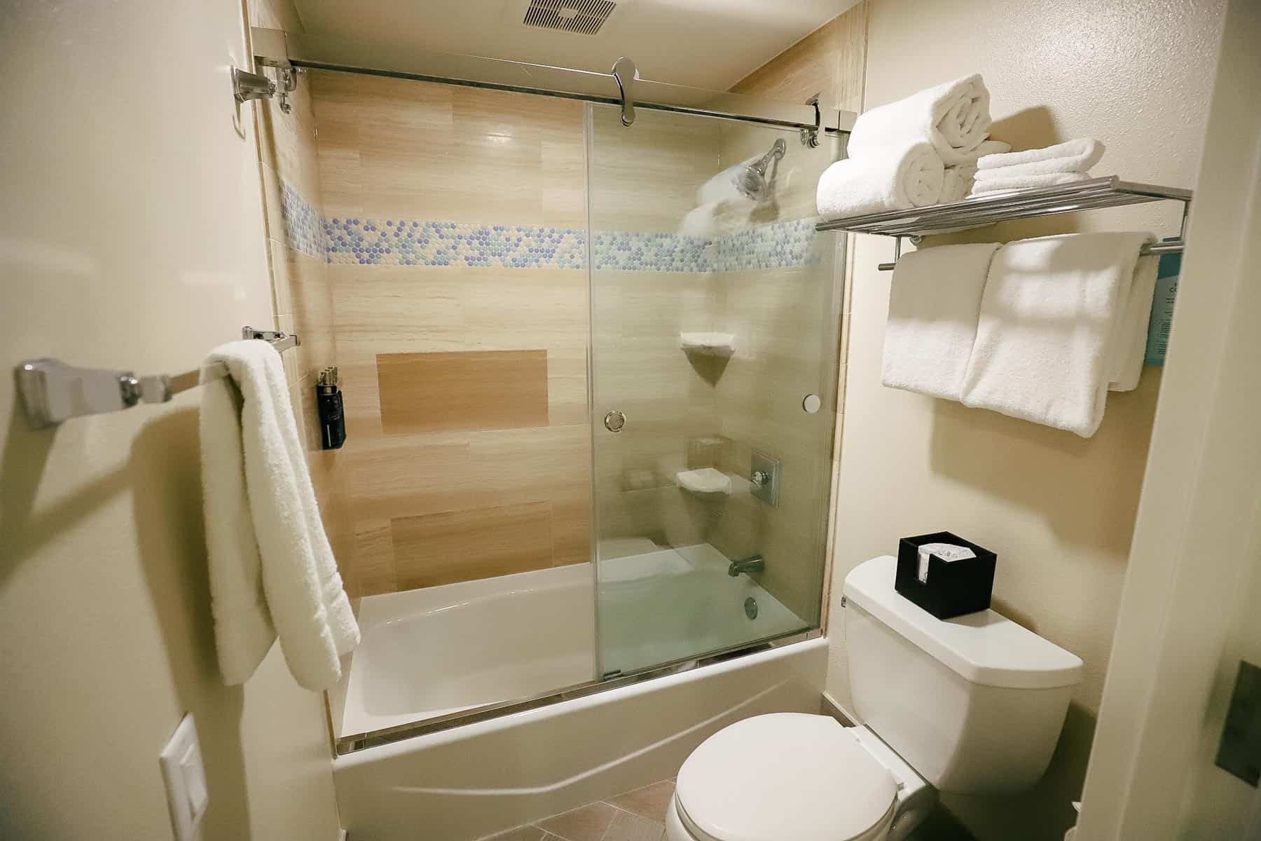 tub with shower and glass doors 