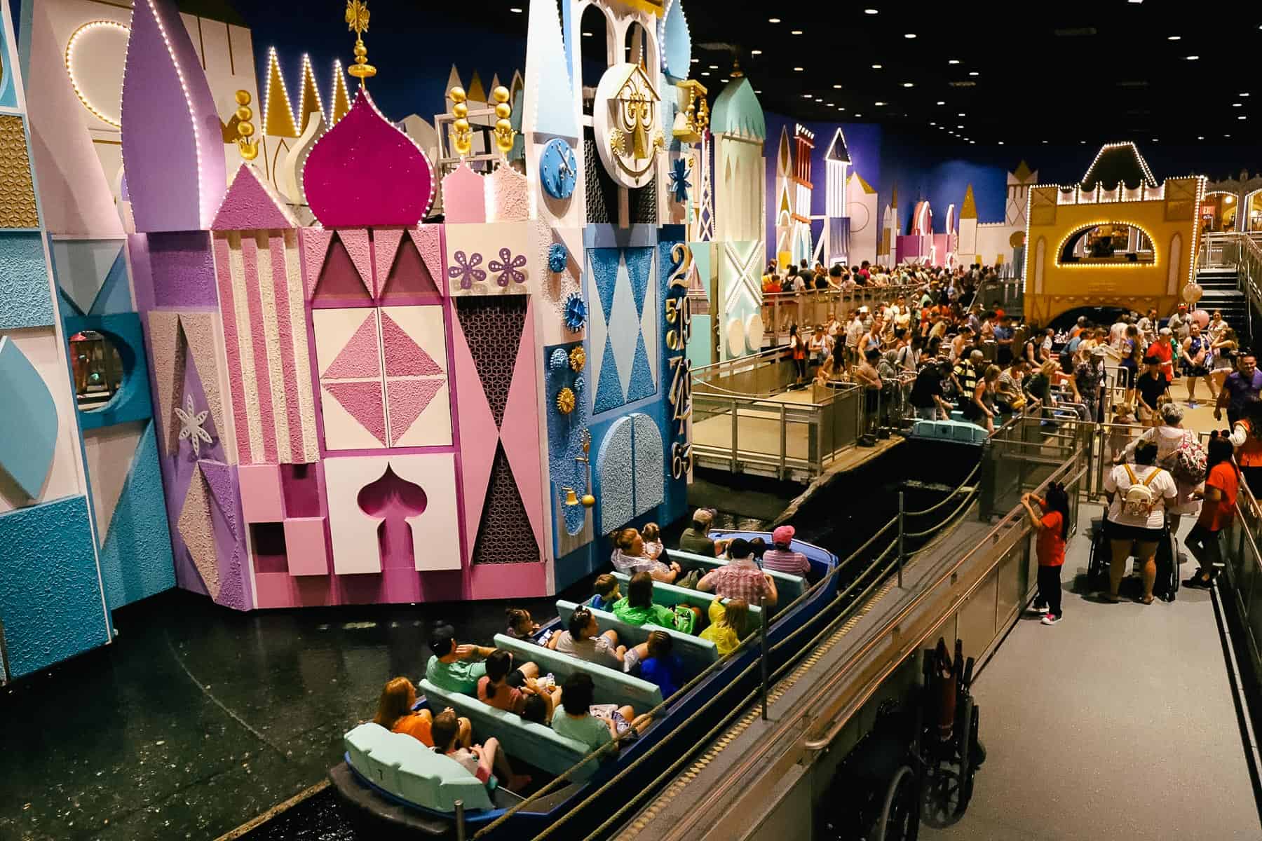 guests waiting to load and unload boats at "it's a small world"