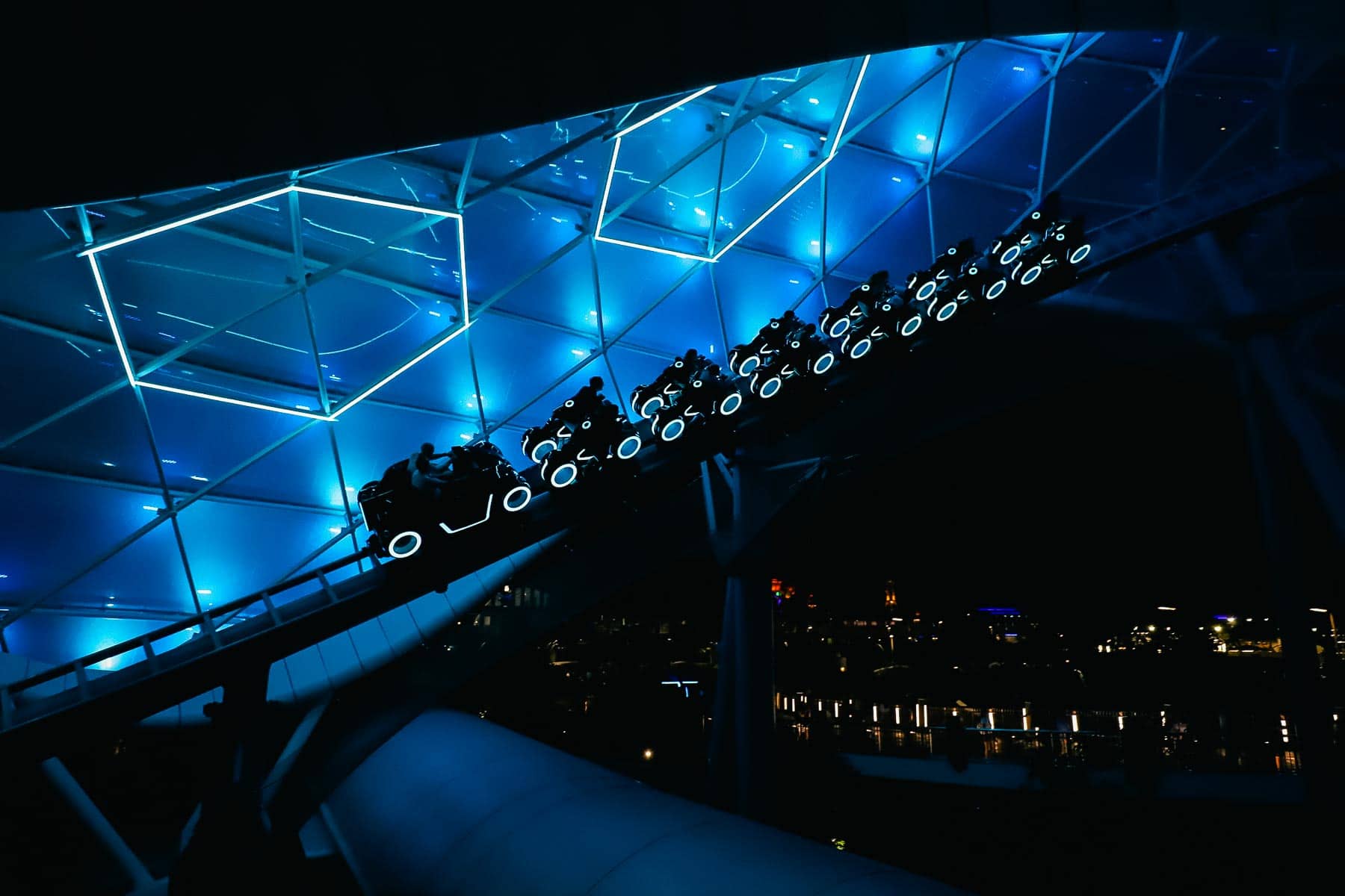 guests riding Tron Lightycle Run at night 