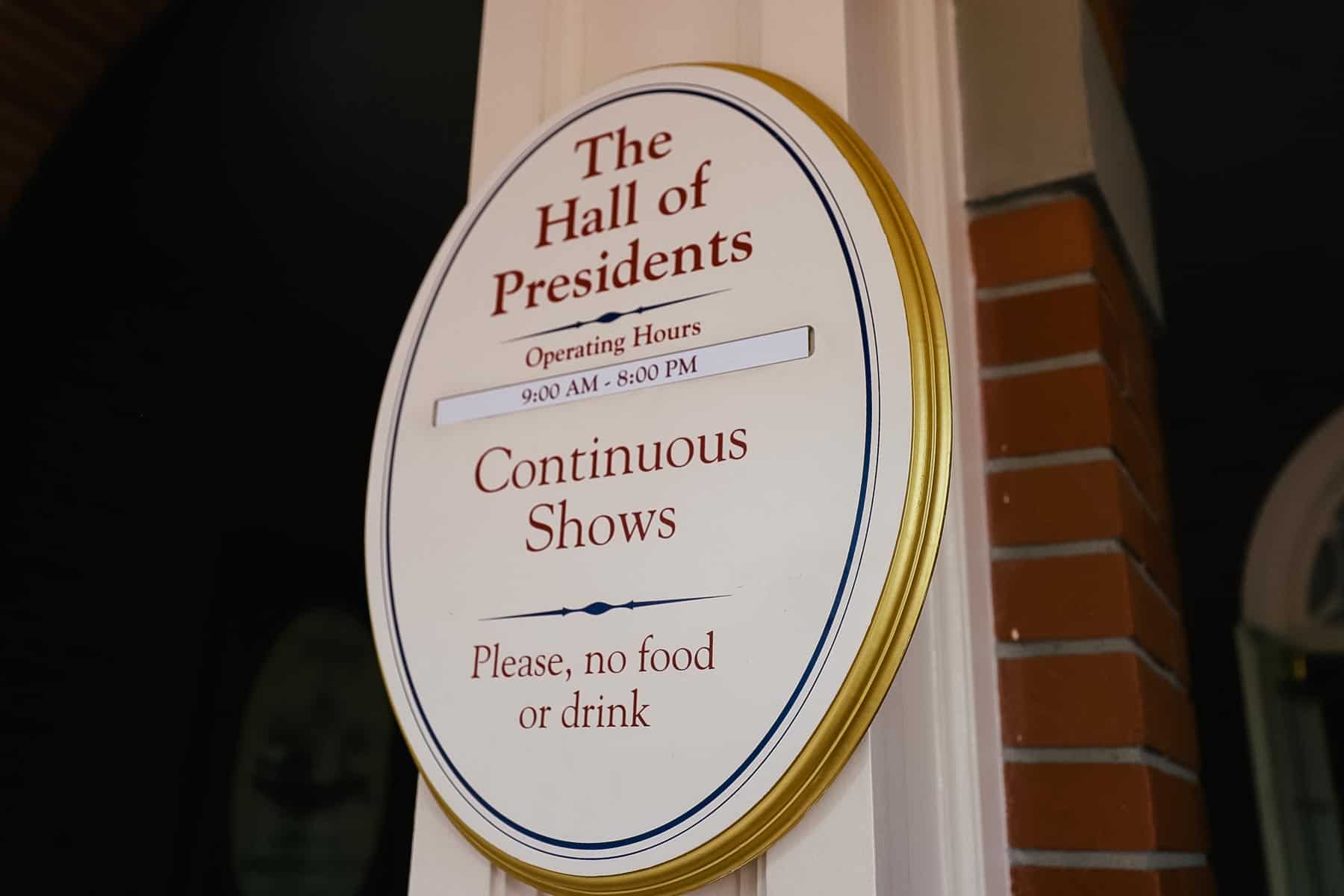 A sign that says The Hall of Presidents, Operating Hours 9:00 a.m. until 8:00 p.m. continuous shows. Please, no food or drink 