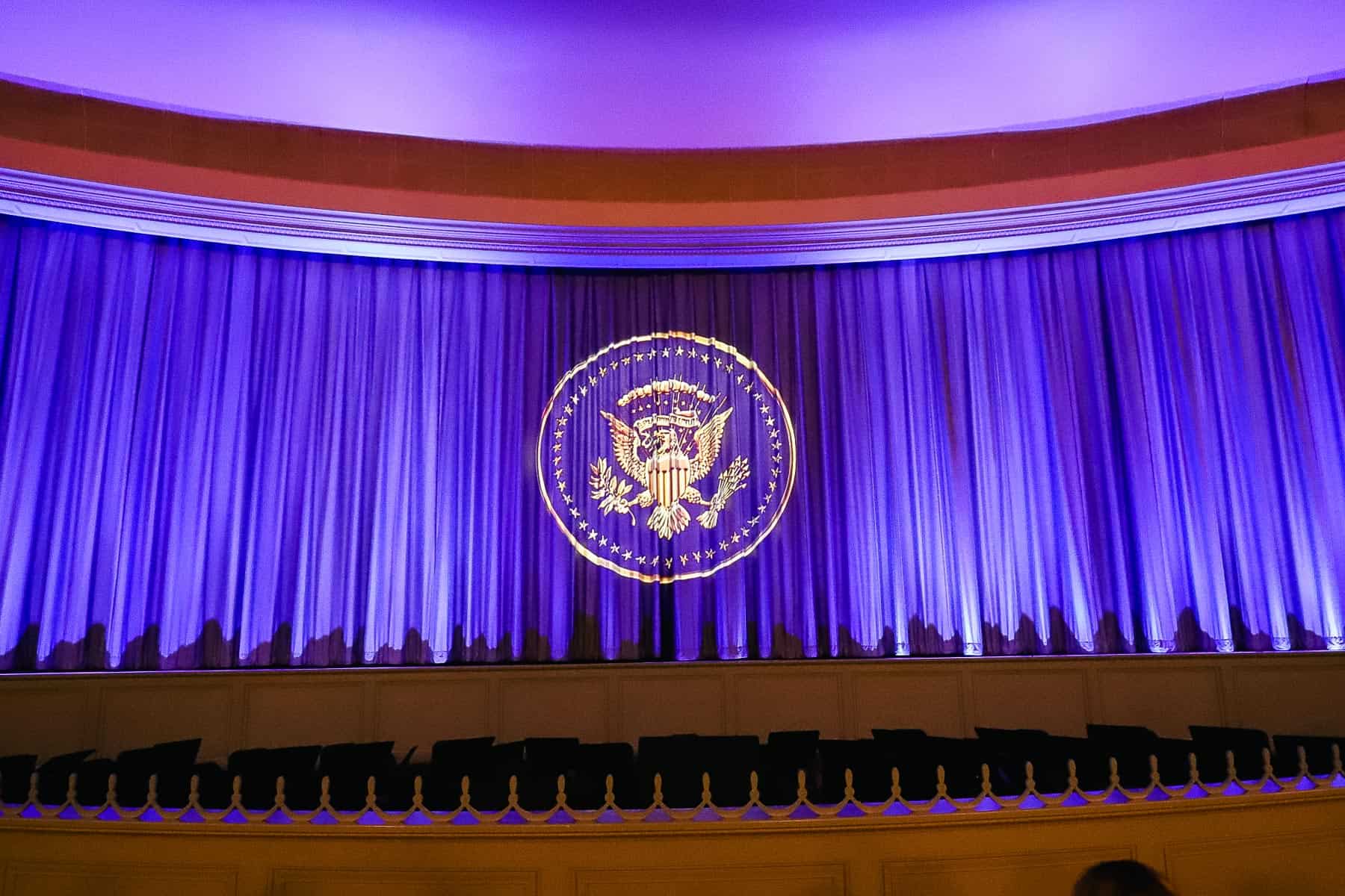 A blue curtain covers the stage. 