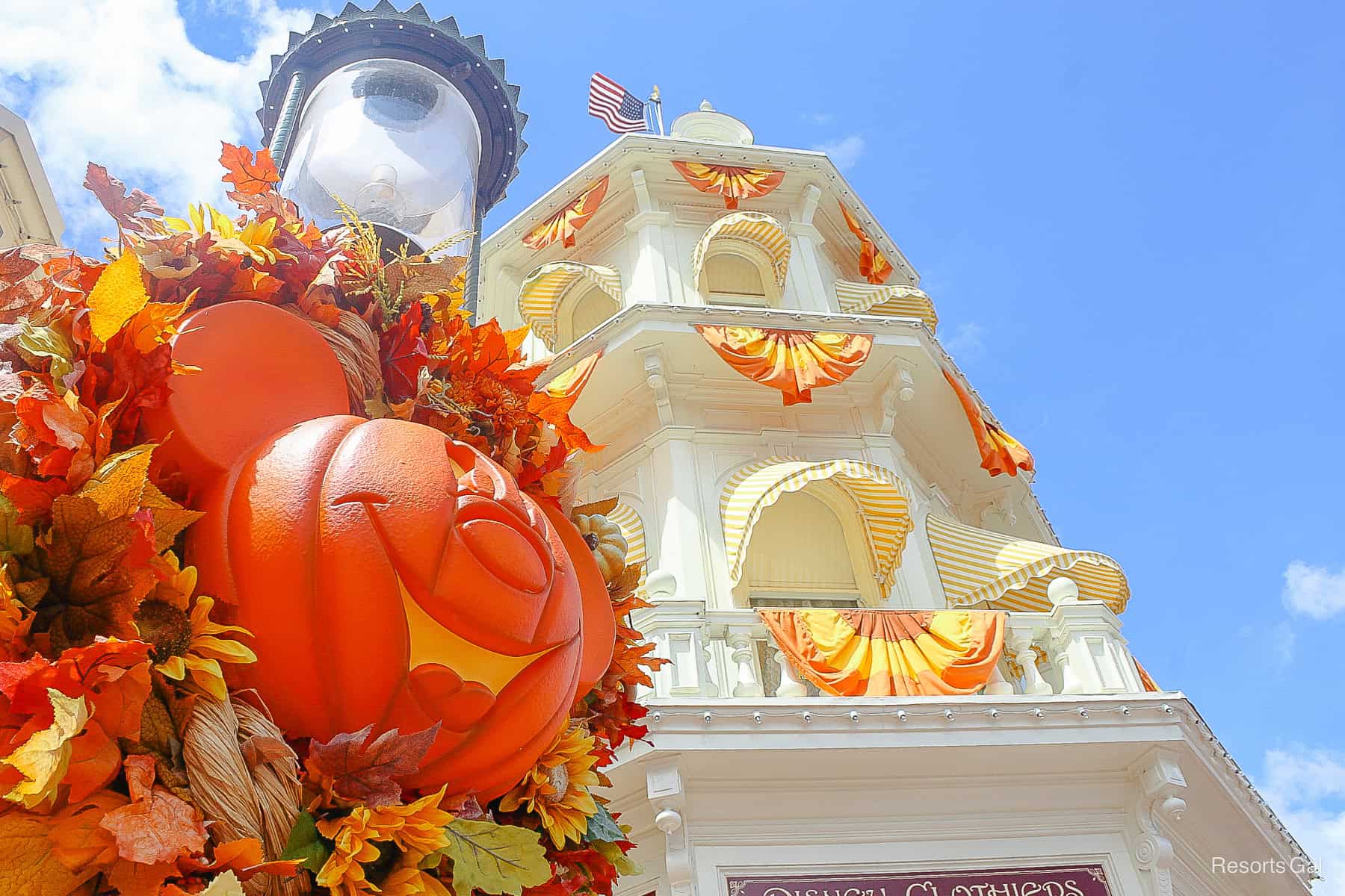 a light pole wrapped with a Mickey pumpkin wreath and buildings dressed in bunting on Main Street during Halloween 