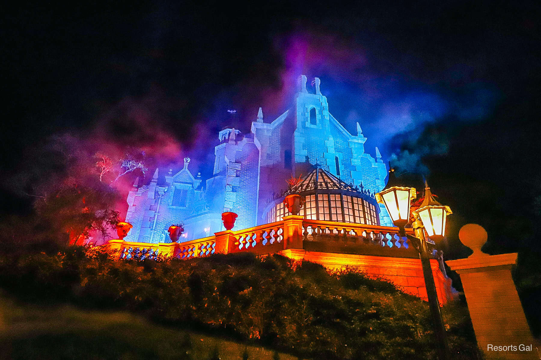 the Haunted Mansion looks spooky with fog and projection lights during Halloween