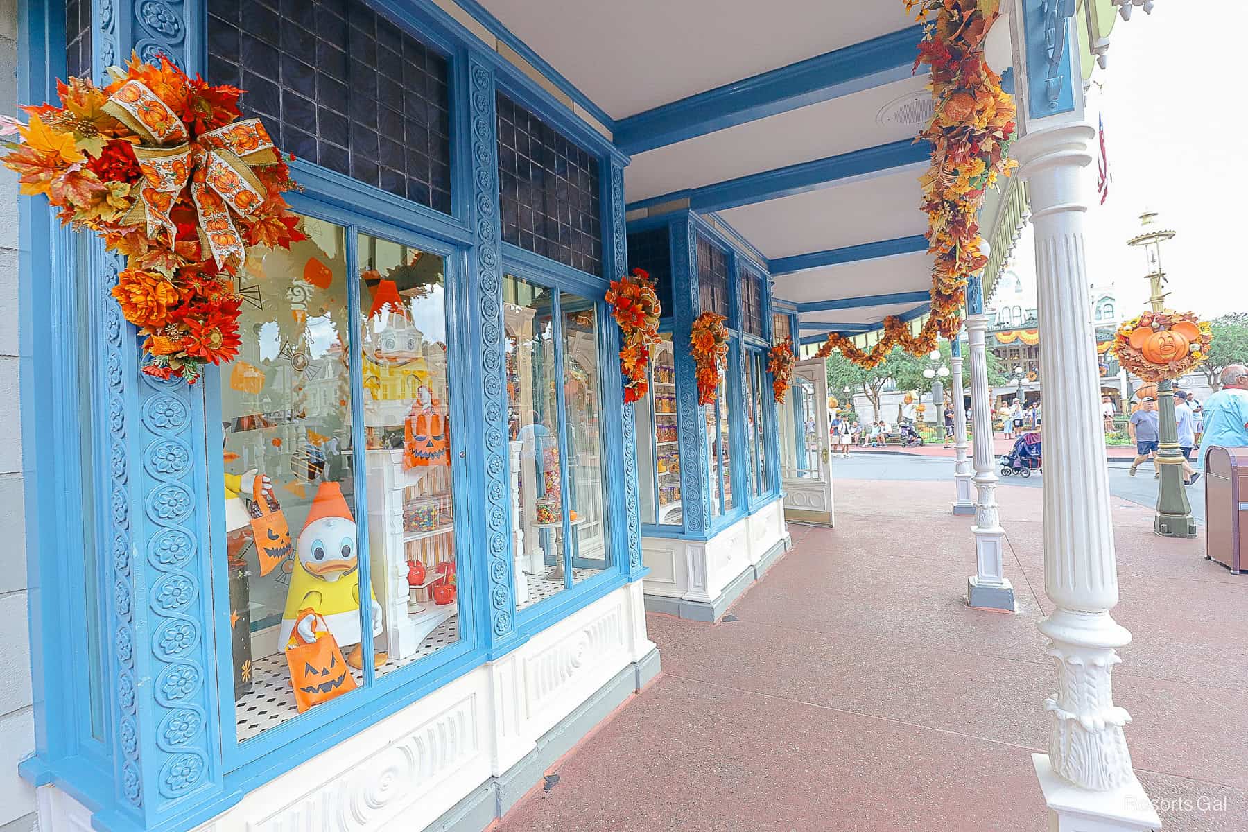 under the awning of the Confectionery on Main Street with Halloween garland 