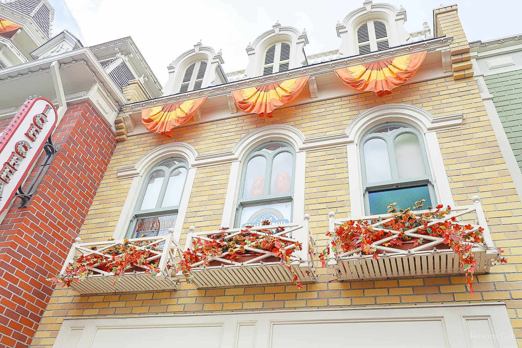 bunting and window boxes with Fall flowers along Main Street at Magic Kingdom 