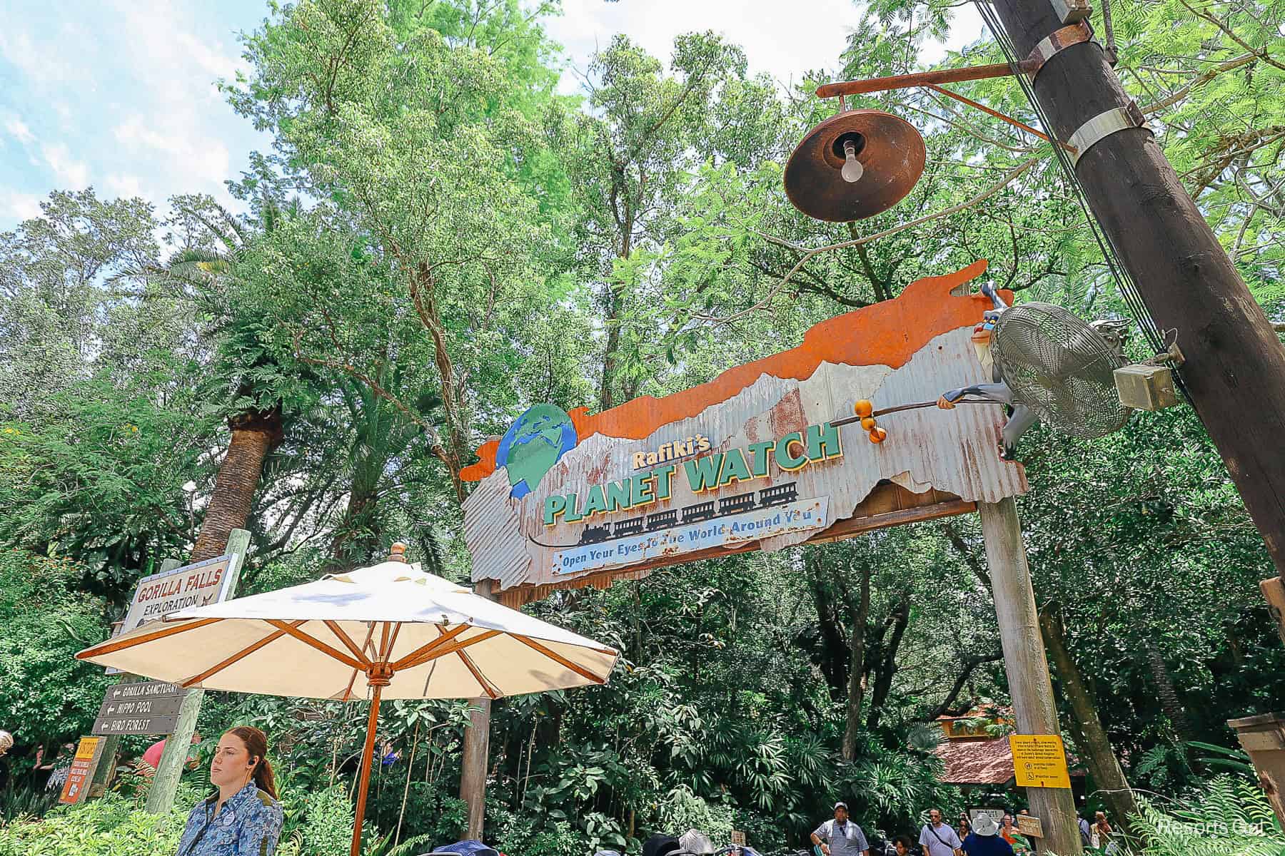guests walking under the sign that leads to the train station at Animal Kingdom