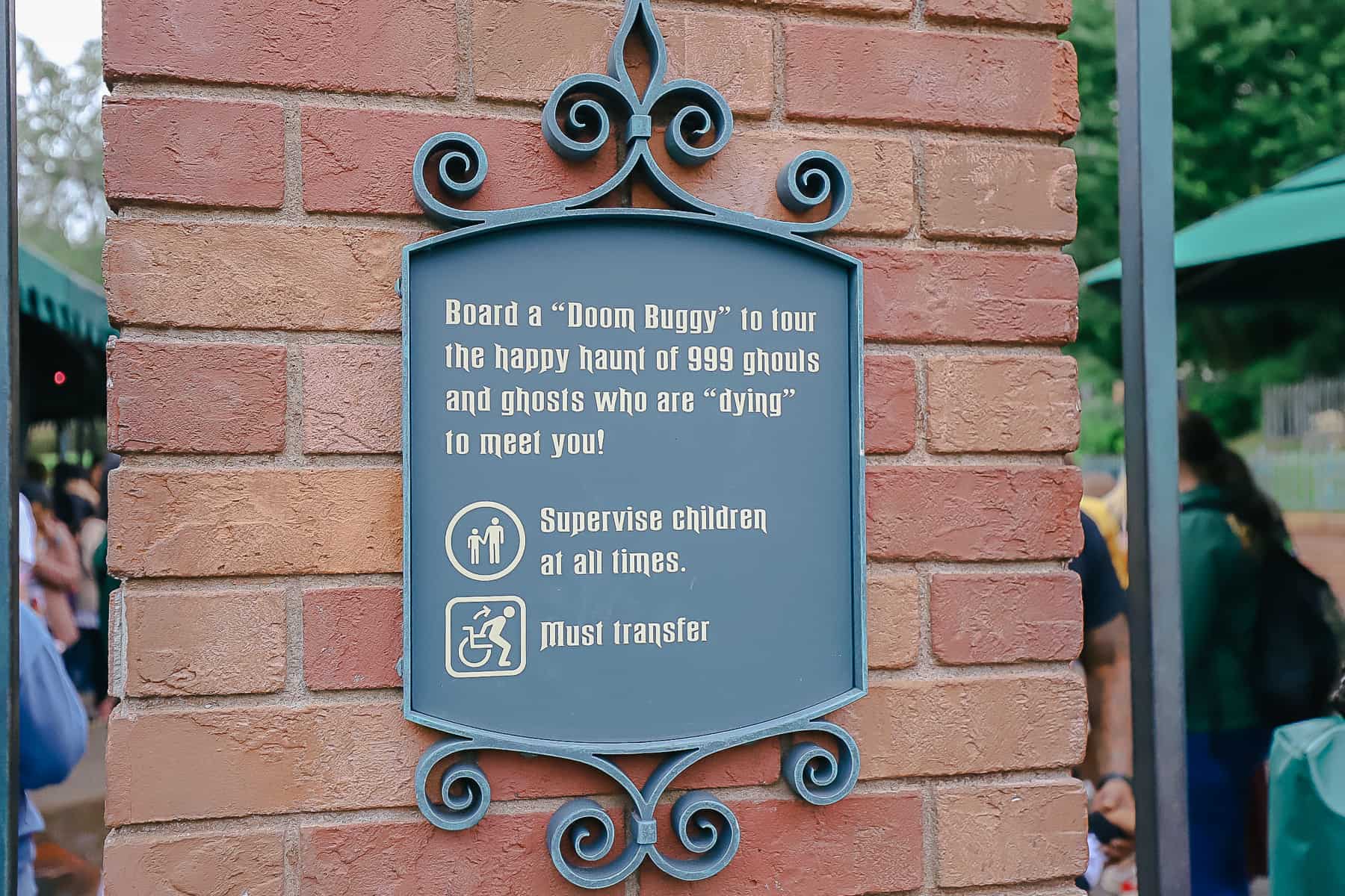 A sign that says board a Doom Buggy to tour the happy haunt of 999 ghouls and ghosts who are dying to meet you. 