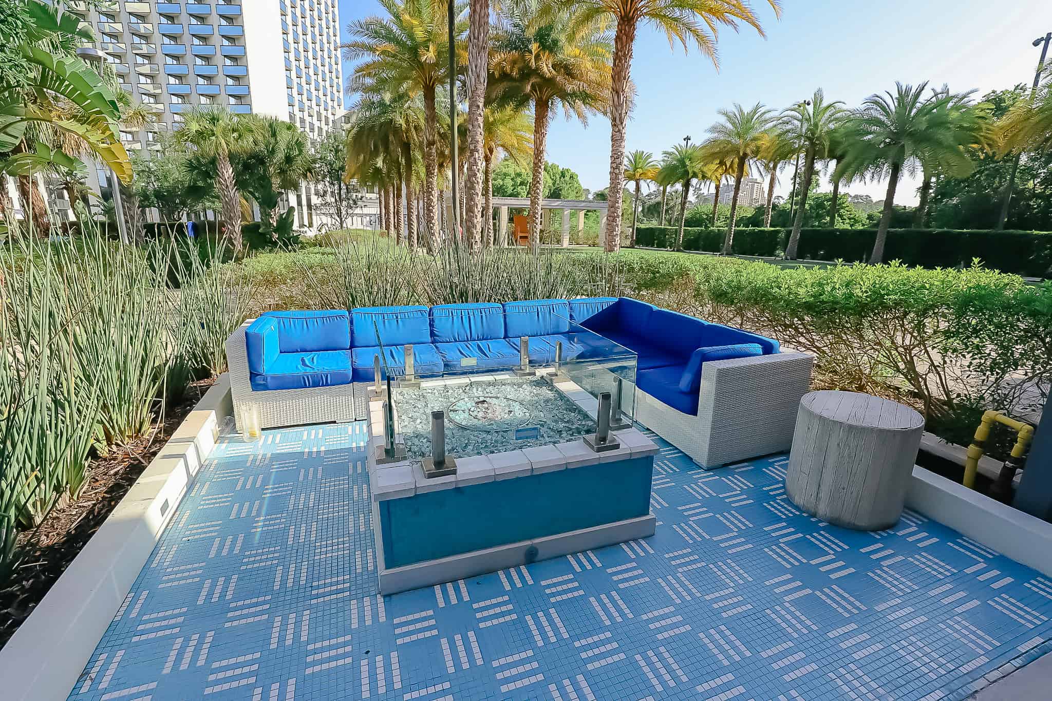 a lounge seating area with a fire pit near the pool 
