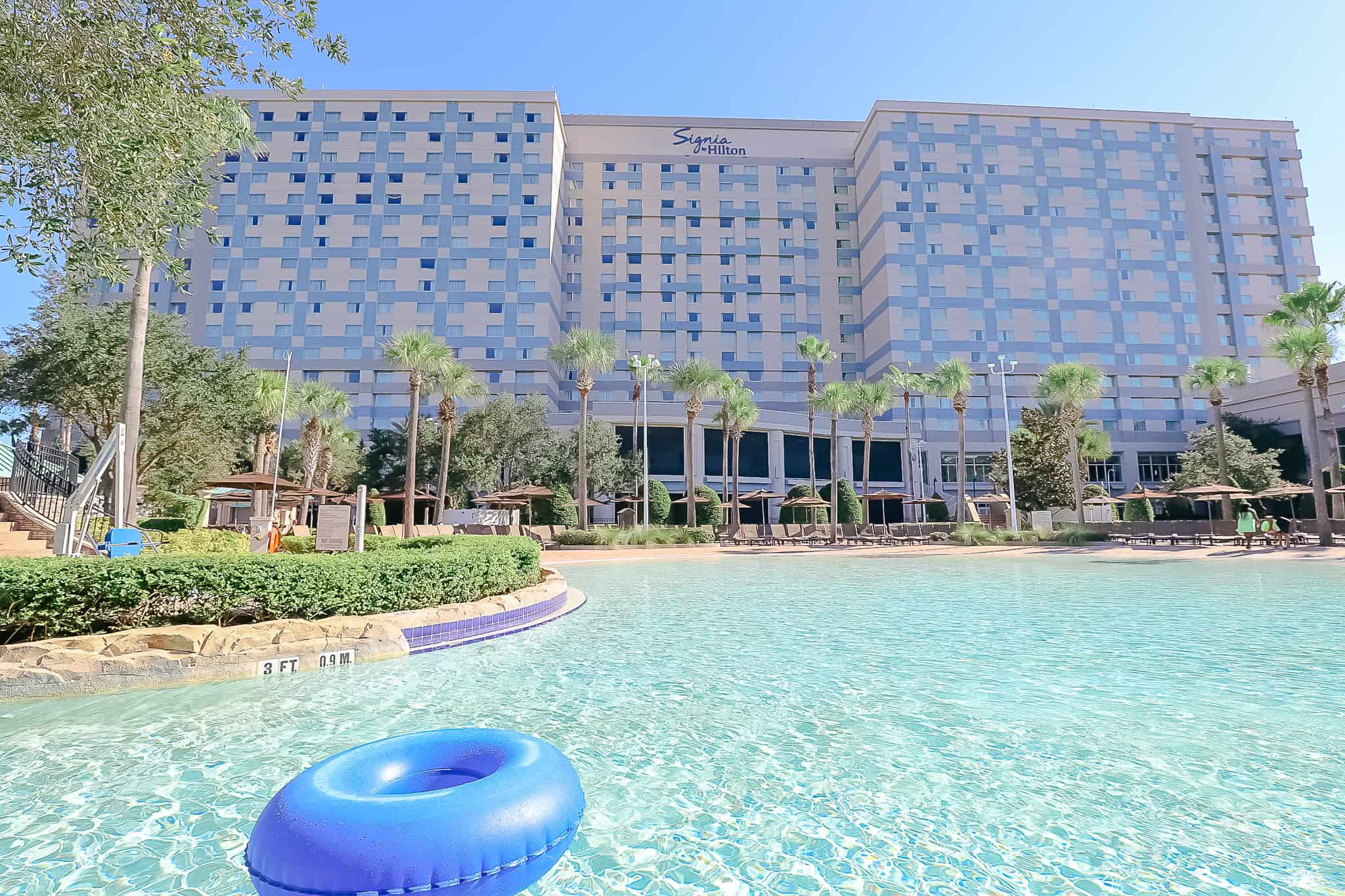 a full view of the Signia Hilton from the opposite side of the pool 